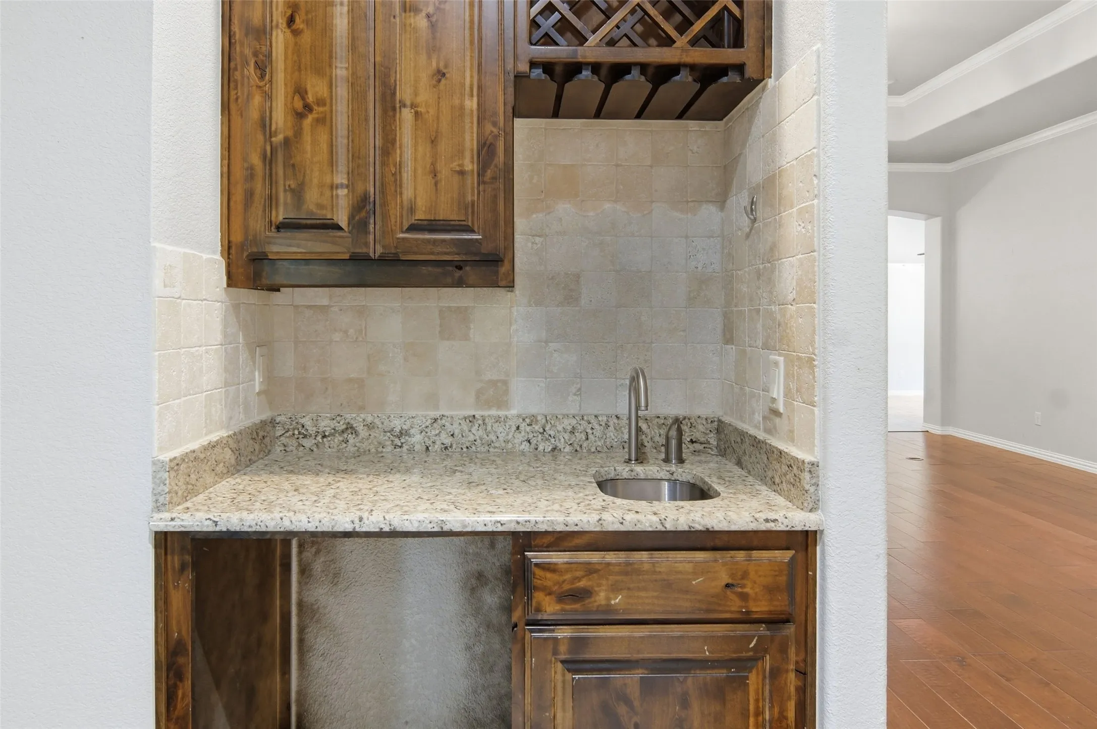 wet bar with granite, tile back splash, wine rack