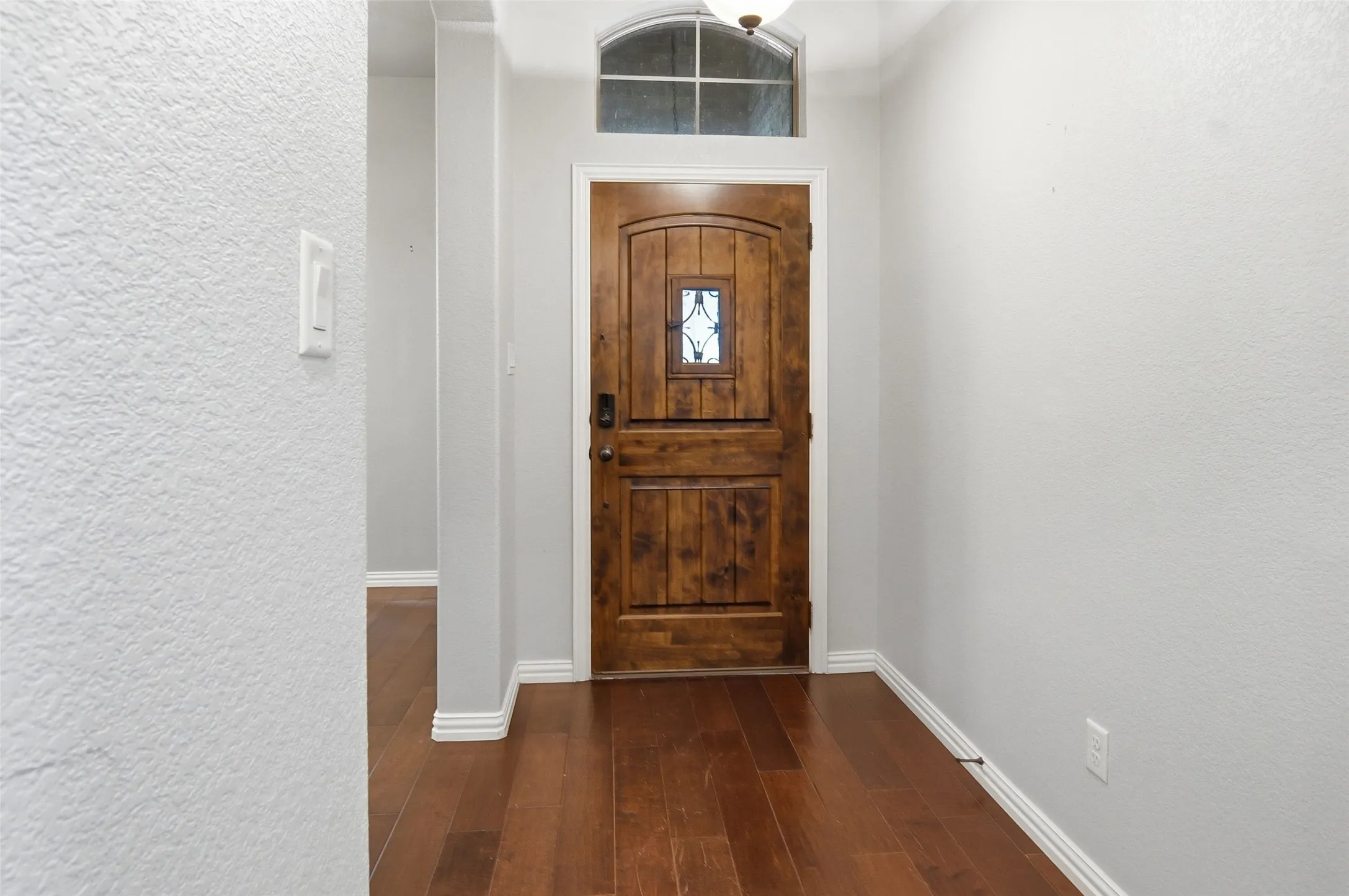 spacious entry with beautiful door and wood flooring