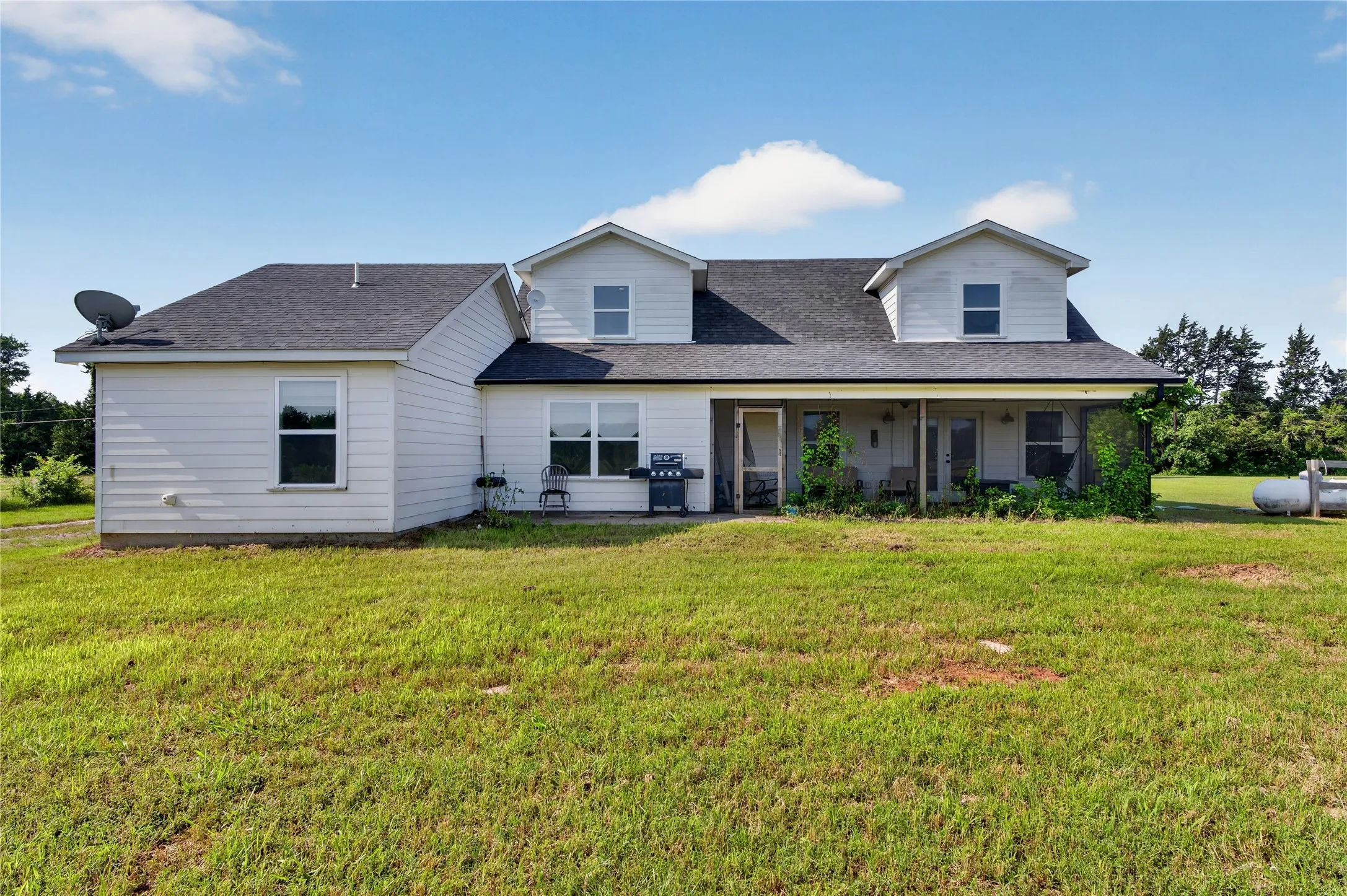 White siding exterior with a dark asphalt shingle roof