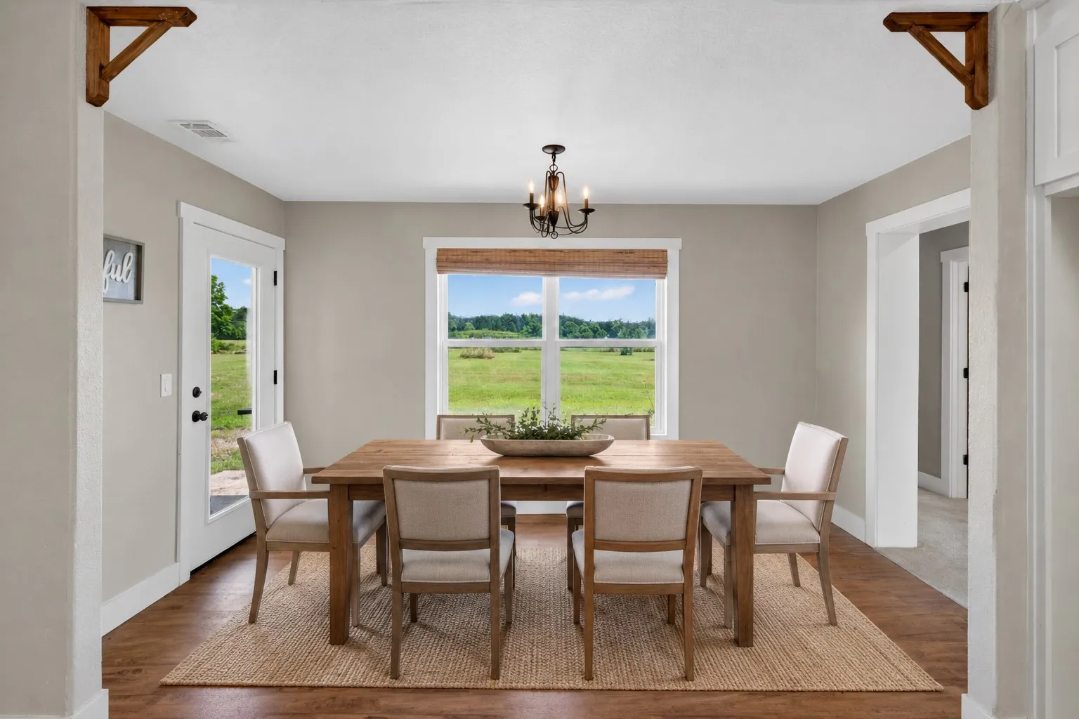 Dining area featuring wood-finish flooring and neutral wall tones. Some elements are virtually staged.