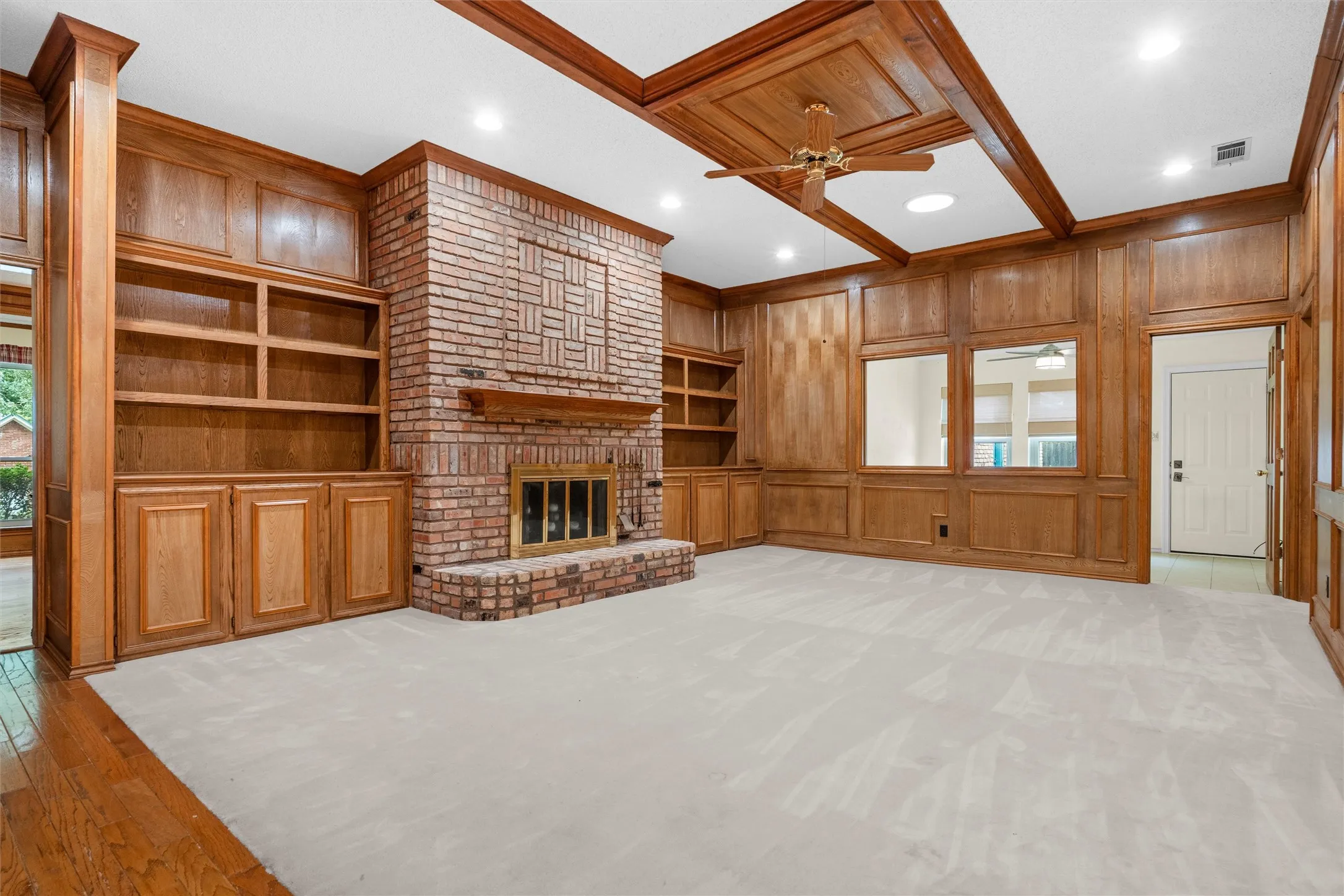 Expansive room featuring extensive wood paneling and built-in shelving