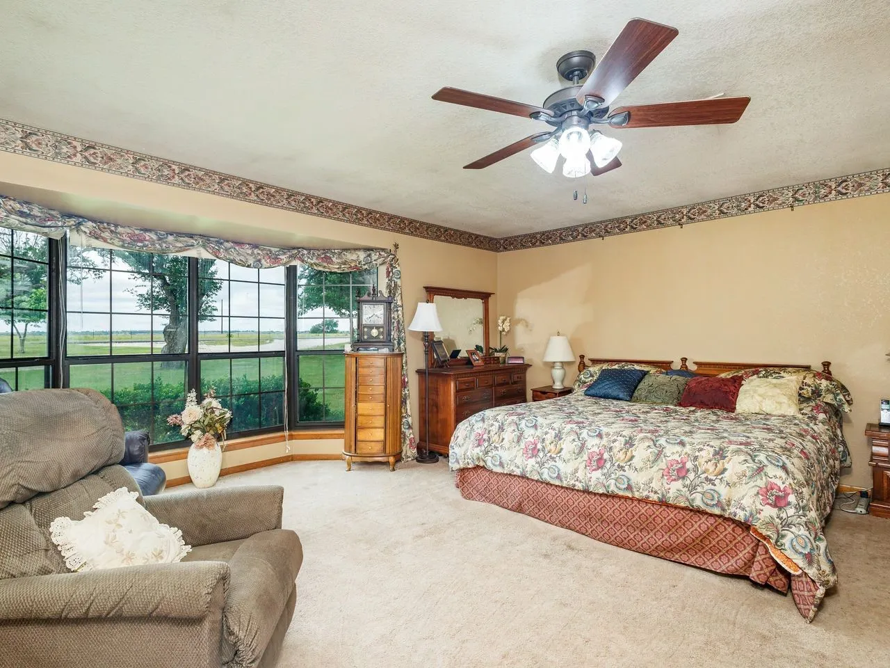 Room featuring a large bay window with multiple panes overlooking a grassy expanse