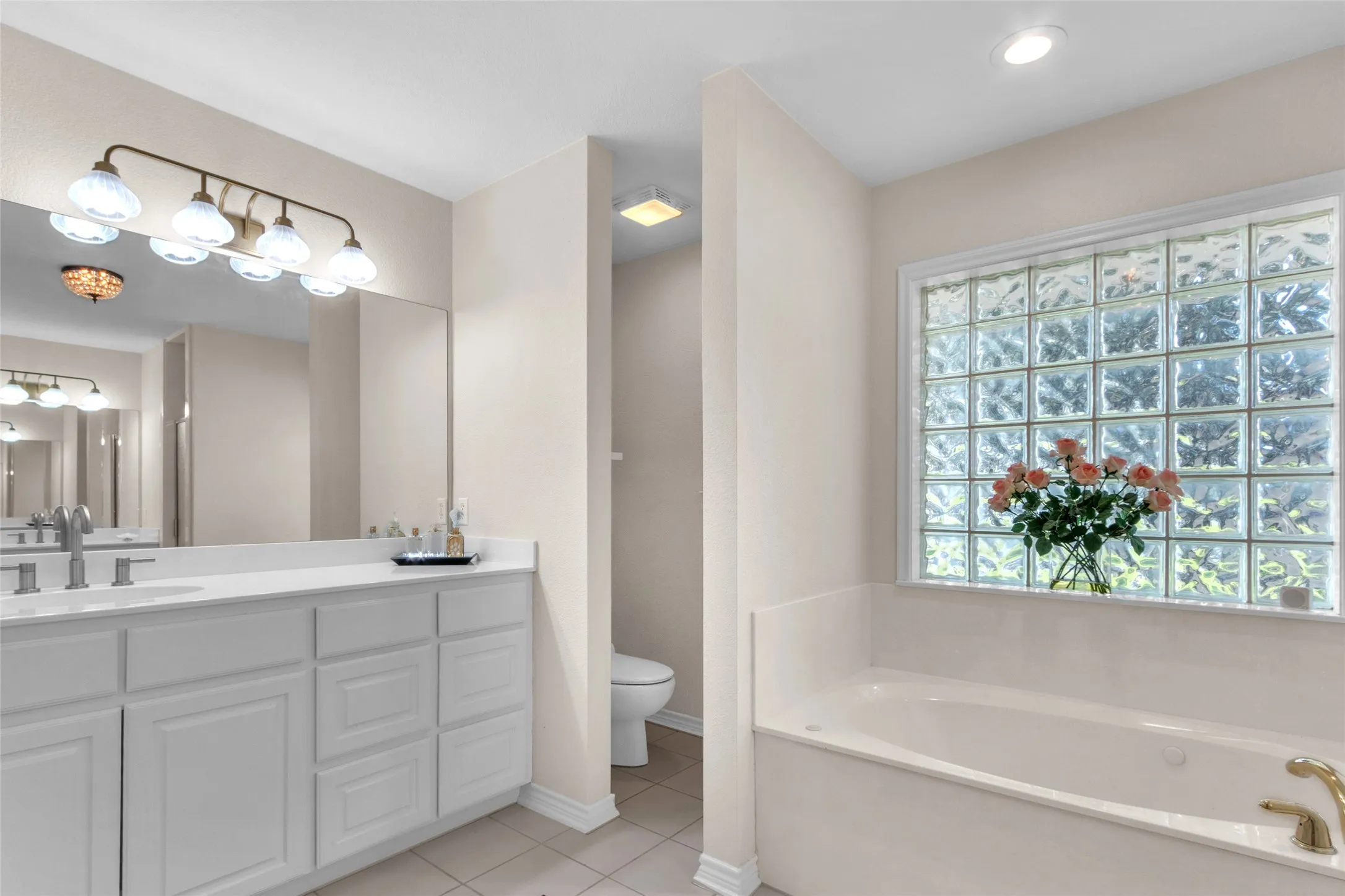 Gorgeous primary bath with walk-in closets on opposite sides of entry, jetted tub, dual vanities and separate shower. Beautiful updated fixtures.