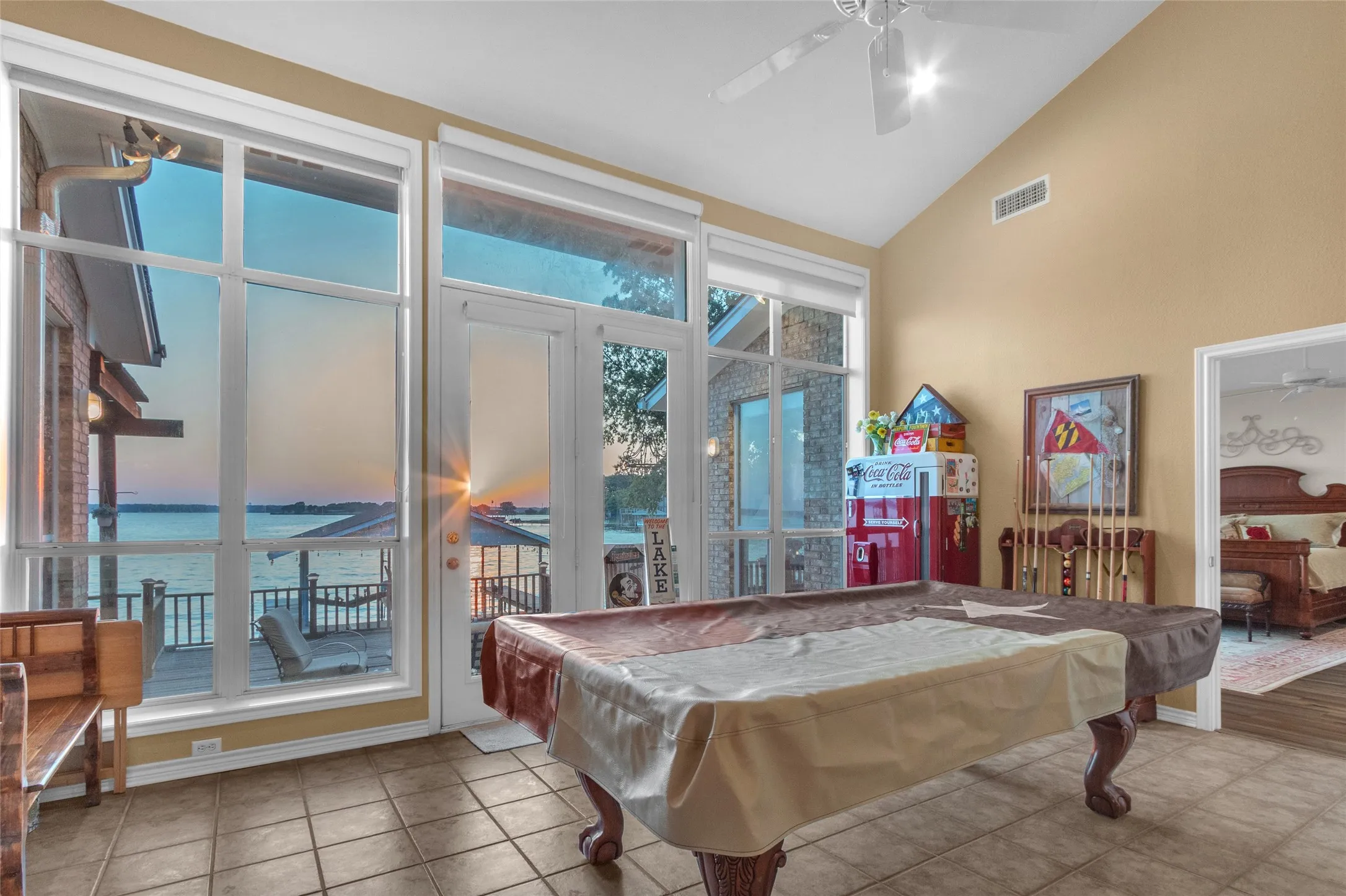 Gameroom featuring tall ceilings, french doors opening to a relaxing deck, built-ins with a mini-fridge and serving  bar access from the Kitchen