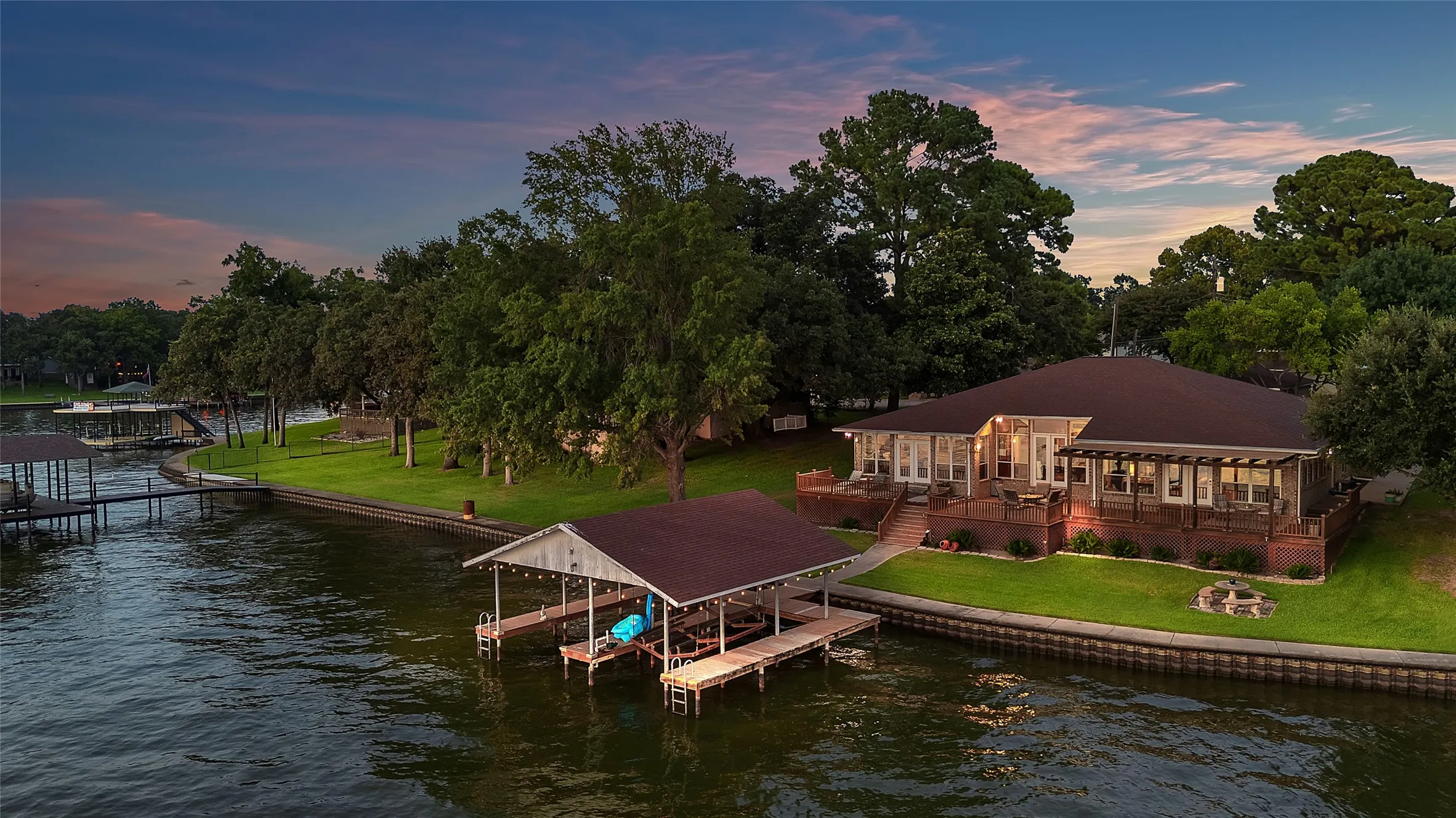 View of dock, home and waterside fire pit
