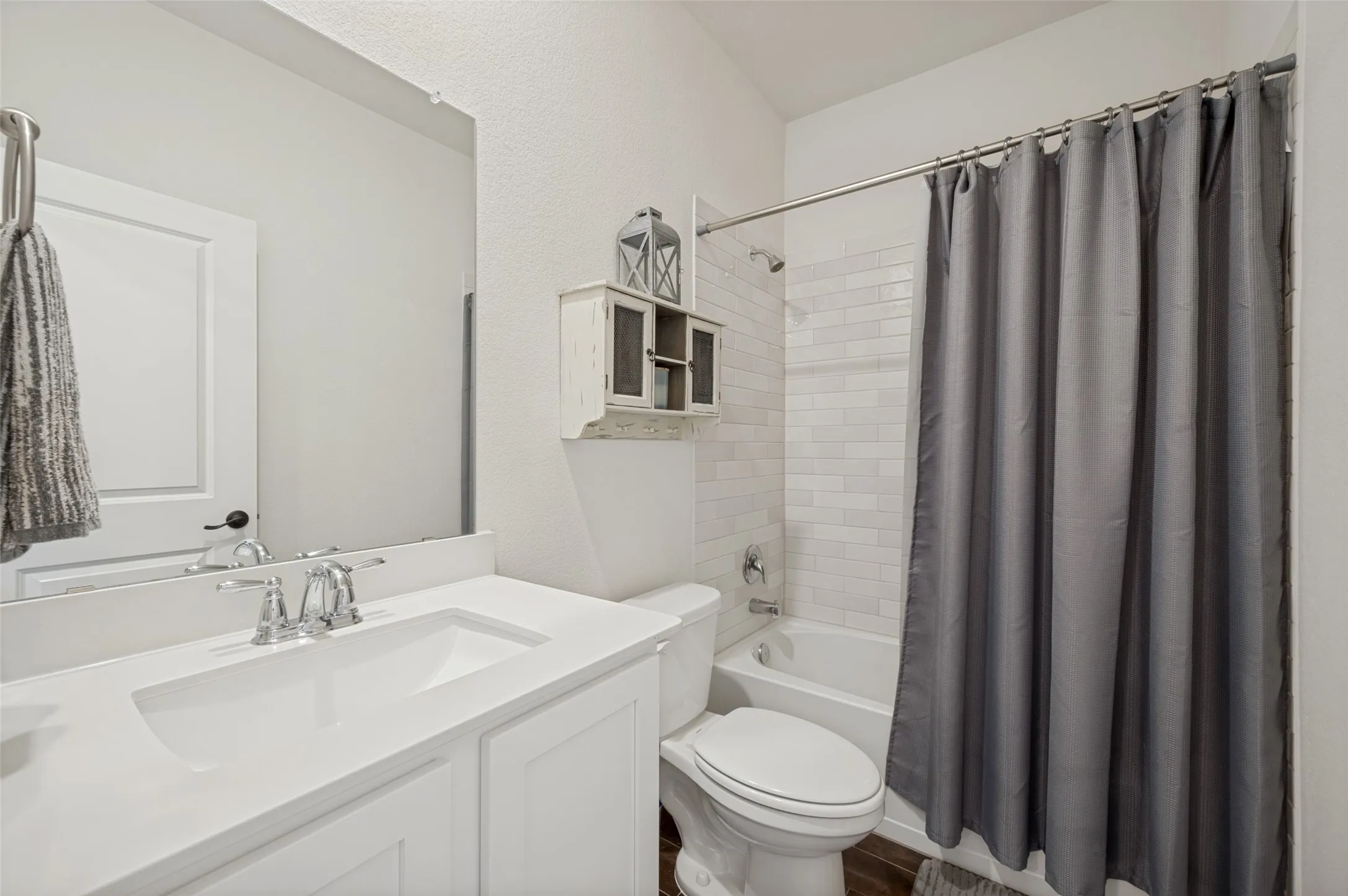 Contemporary bathroom featuring a single white vanity with an integrated sink, chrome faucet, and expansive mirror