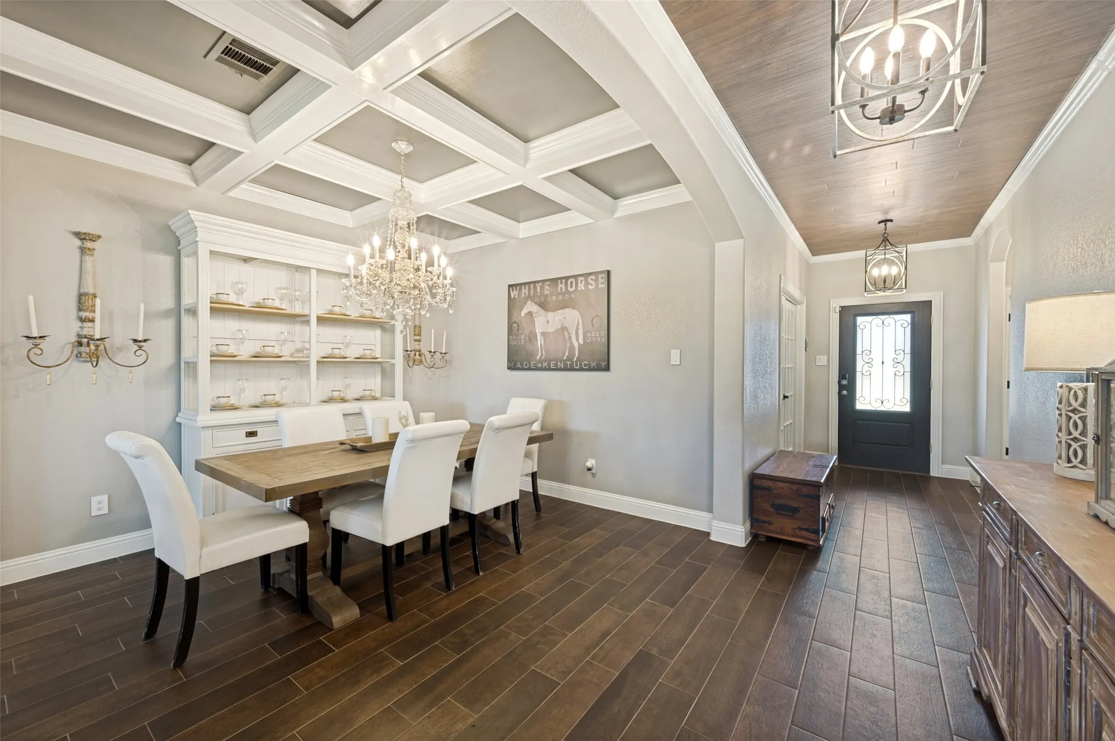 Formal dining area featuring coffered ceilings and a crystal chandelier