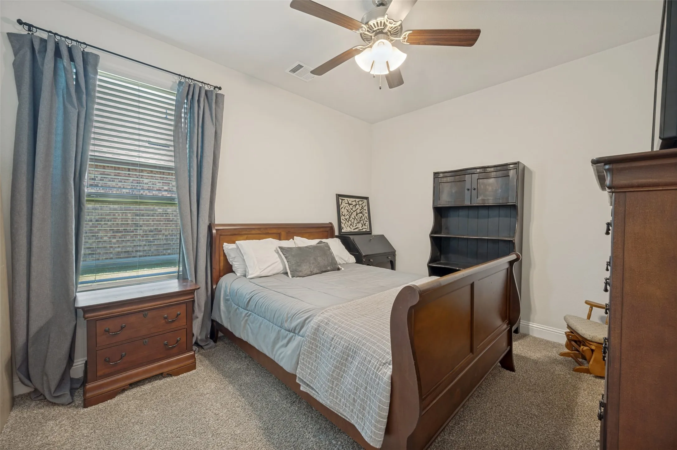 Carpeted room featuring a ceiling fan with integrated lighting, a window with blinds, and white walls