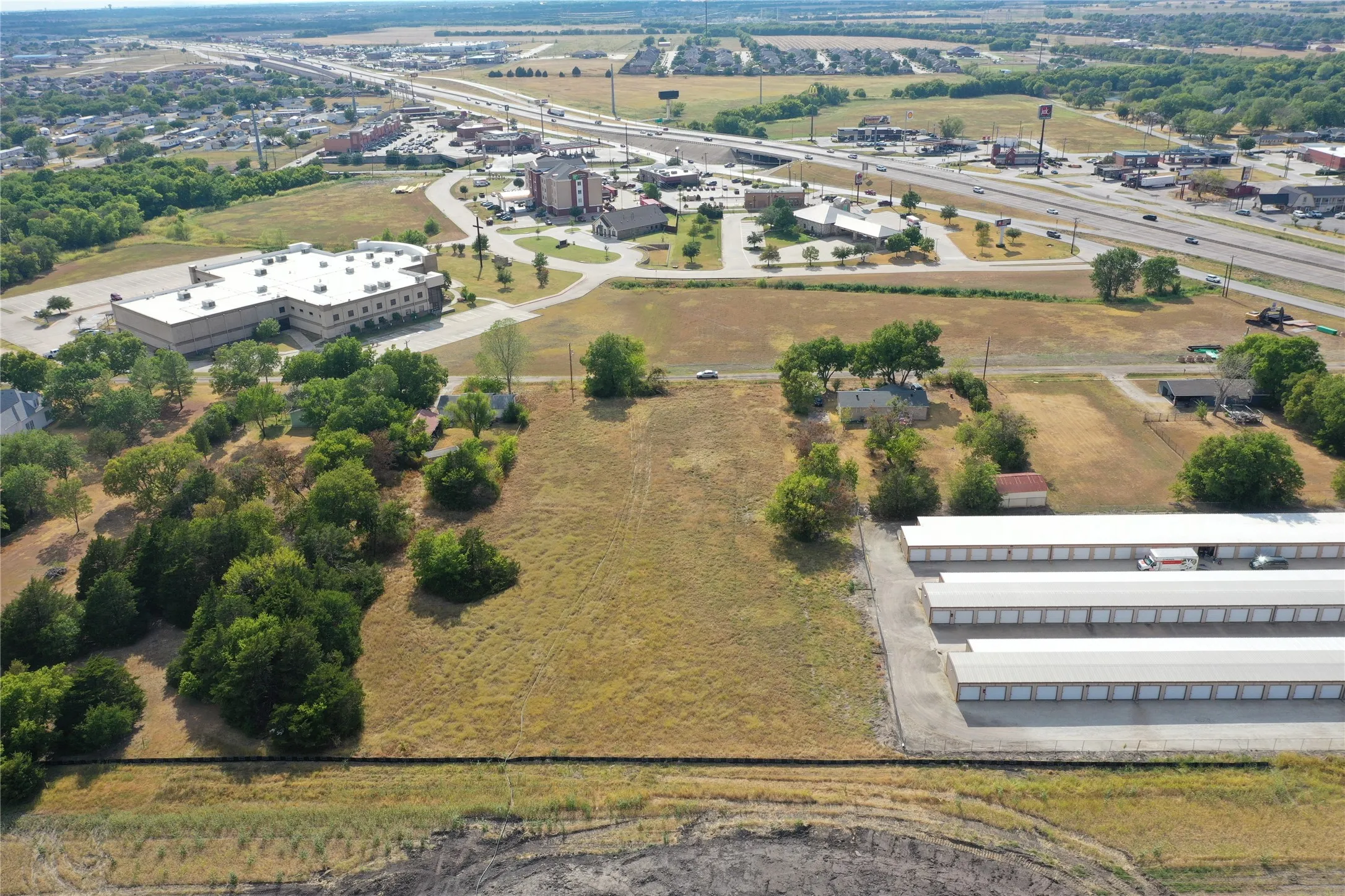 Expansive open land featuring mature trees and clear ground cover