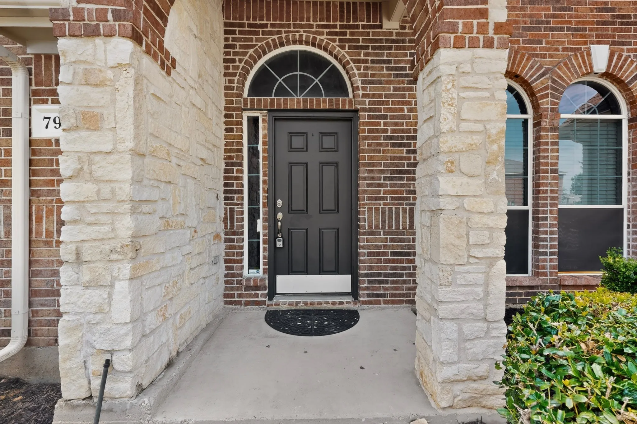 Entryway featuring a dark paneled door with an arched transom window