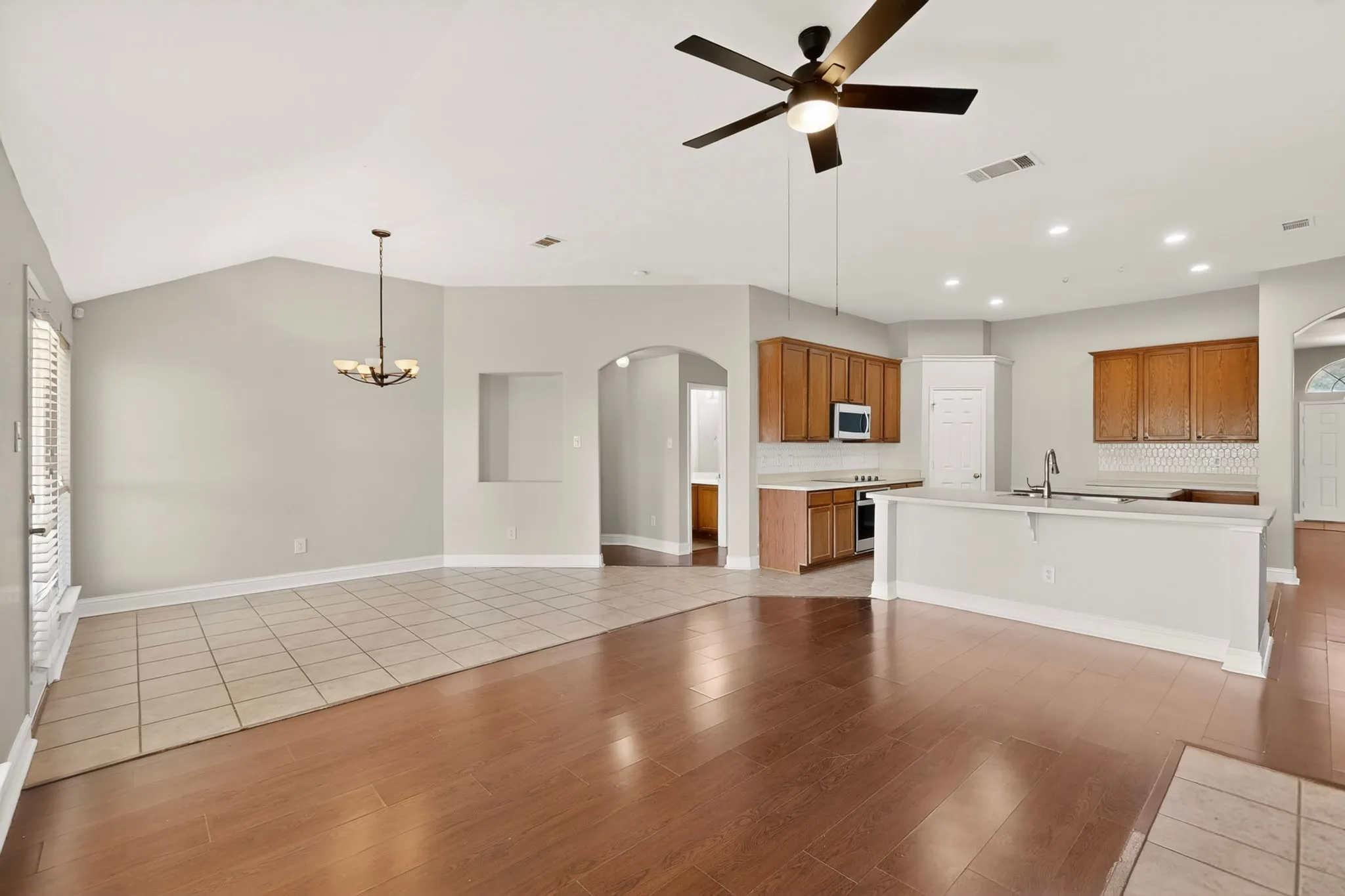 Open-concept living space featuring wood-finish flooring, a vaulted ceiling, and recessed lighting