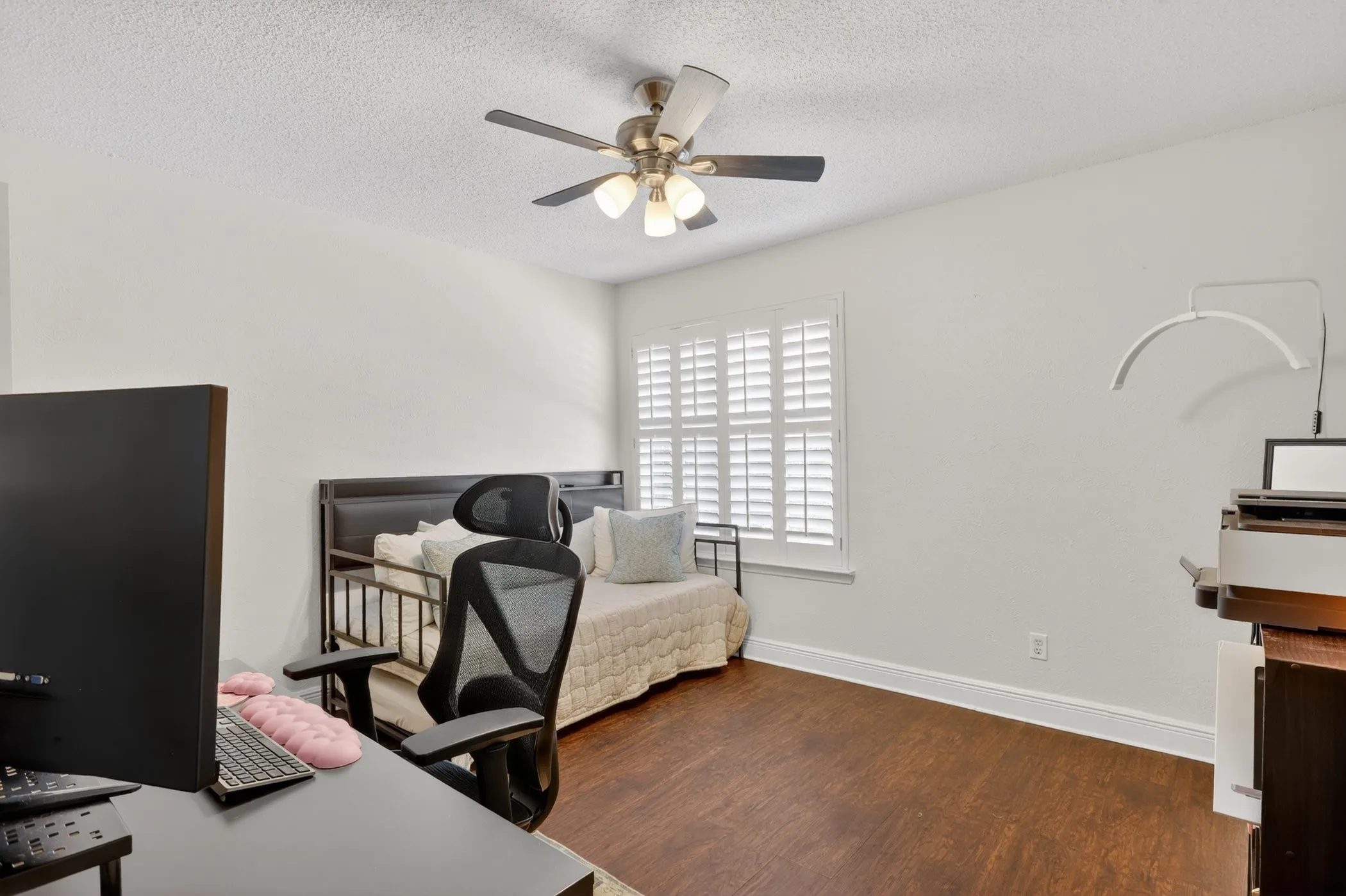 Interior room featuring a ceiling fan, white walls, and wood-finish flooring