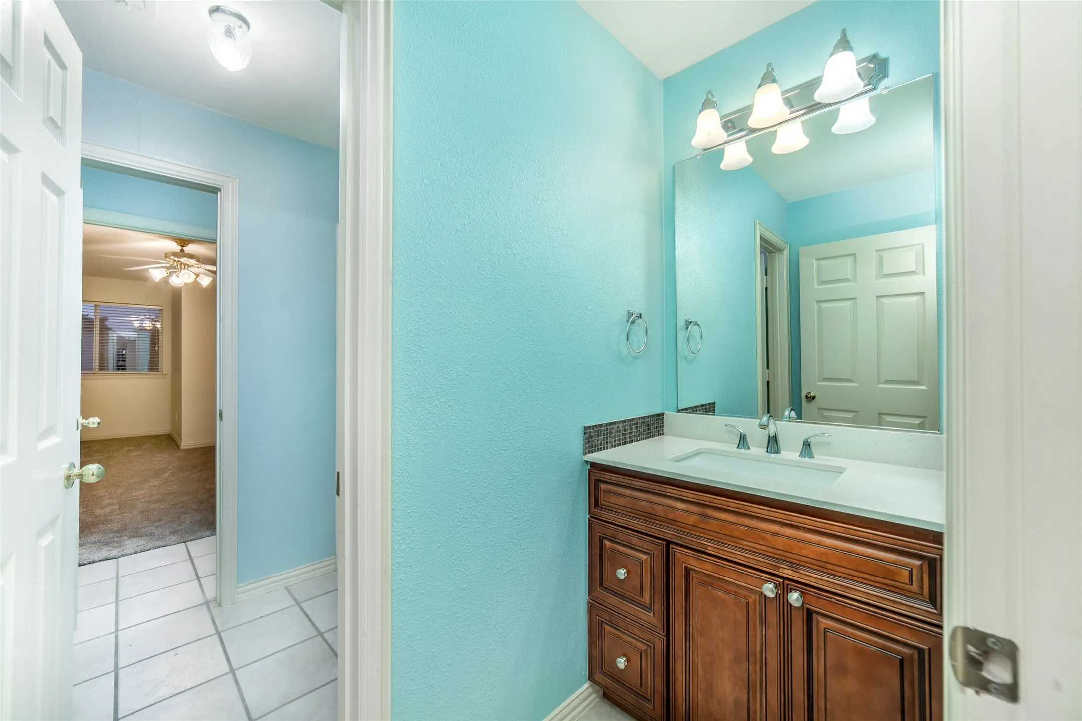 Bathroom vanity featuring a light countertop, integrated sink, and an undermount faucet