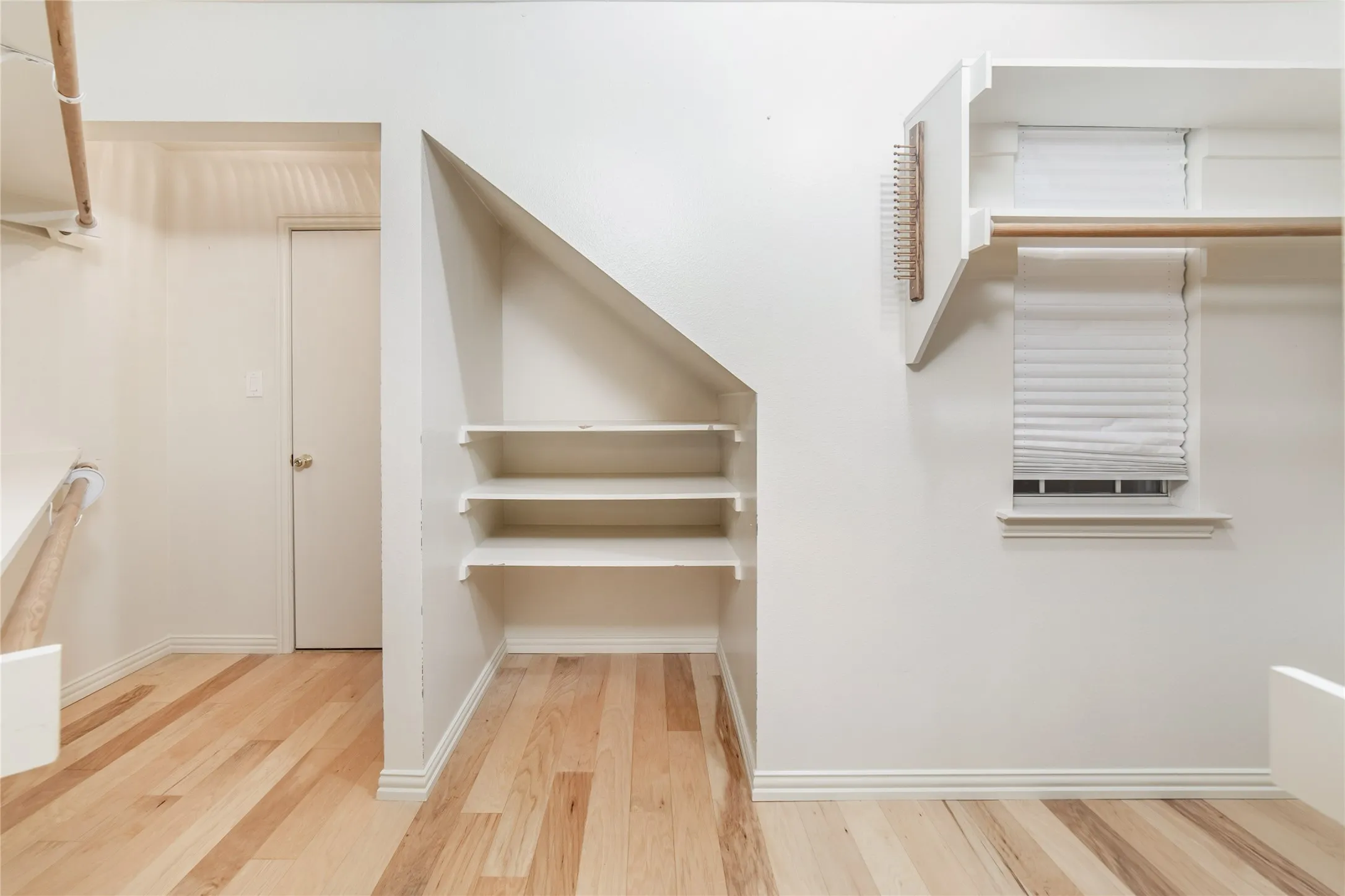 Built-in shelving and hanging rods offer versatile storage options within this space