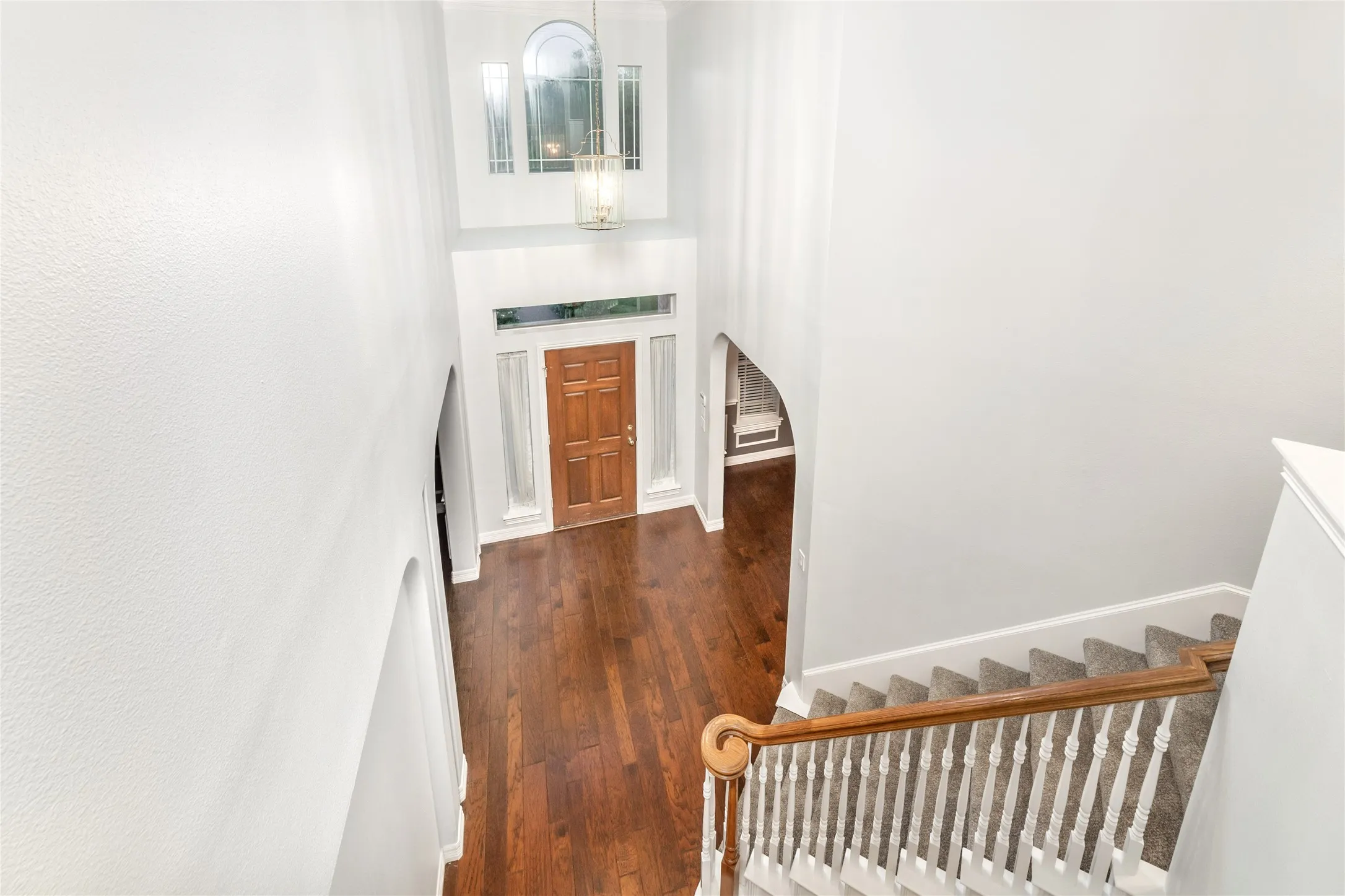 Two-story foyer with rich wood-finish flooring