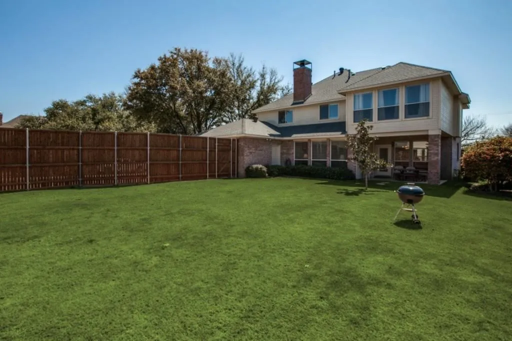 Expansive green lawn with a privacy fence