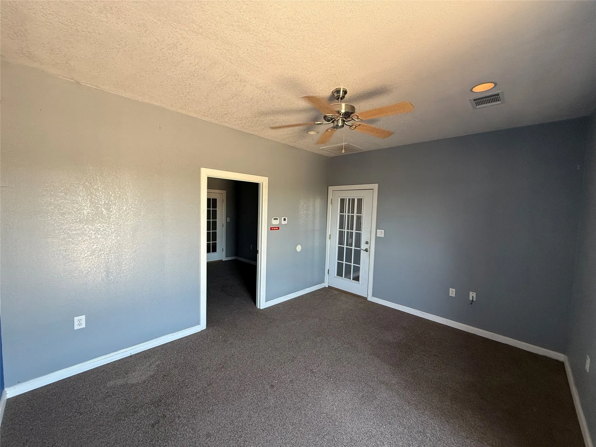 Room featuring painted walls, carpet flooring, and a ceiling fan with integrated lighting