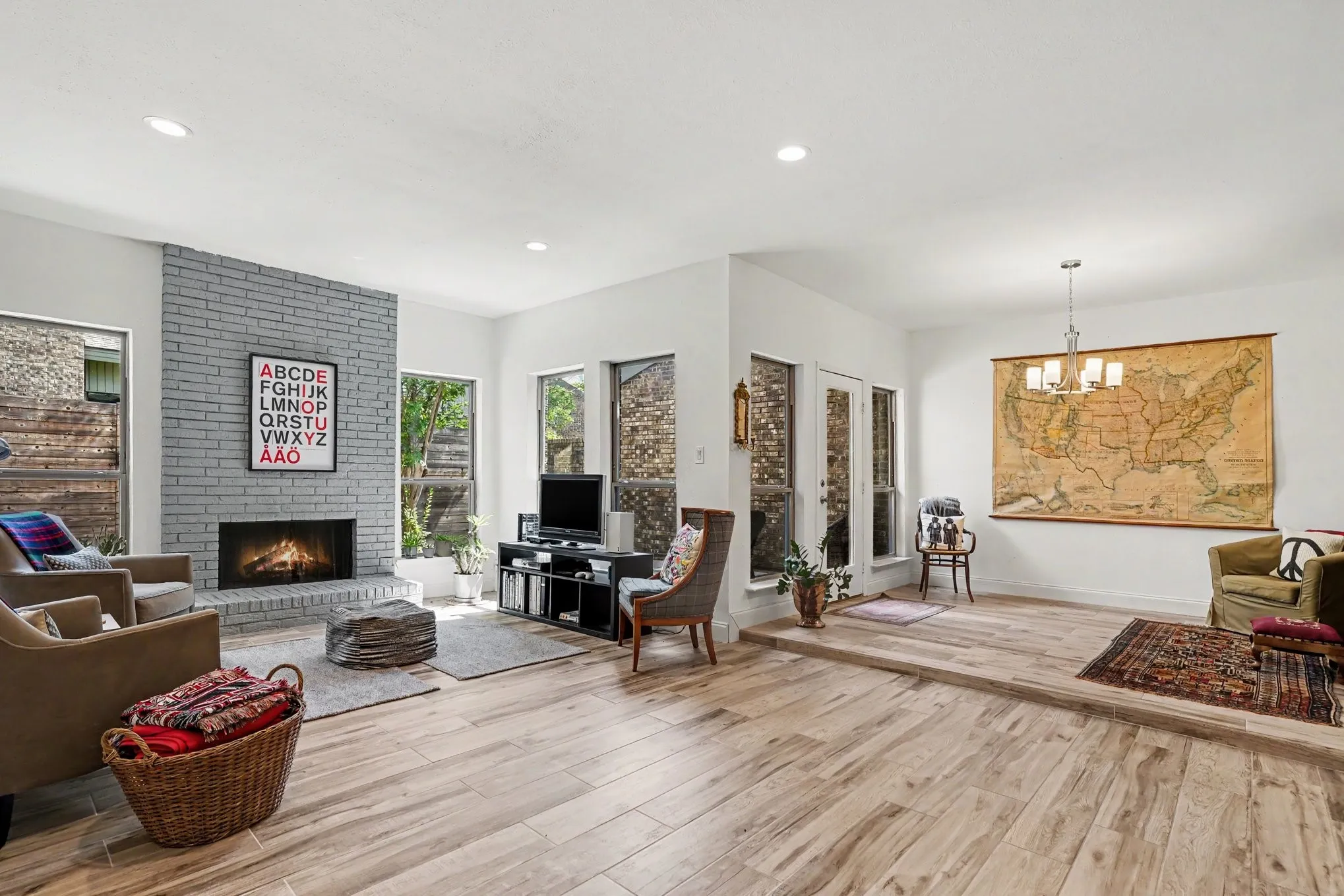 Spacious living area featuring wood-look flooring and a gray brick fireplace with a hearth
