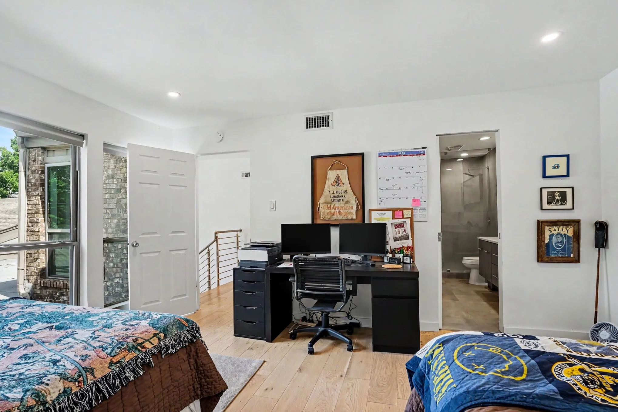 Bright room featuring wide plank wood-finish flooring, recessed lighting, and a contemporary metal railing