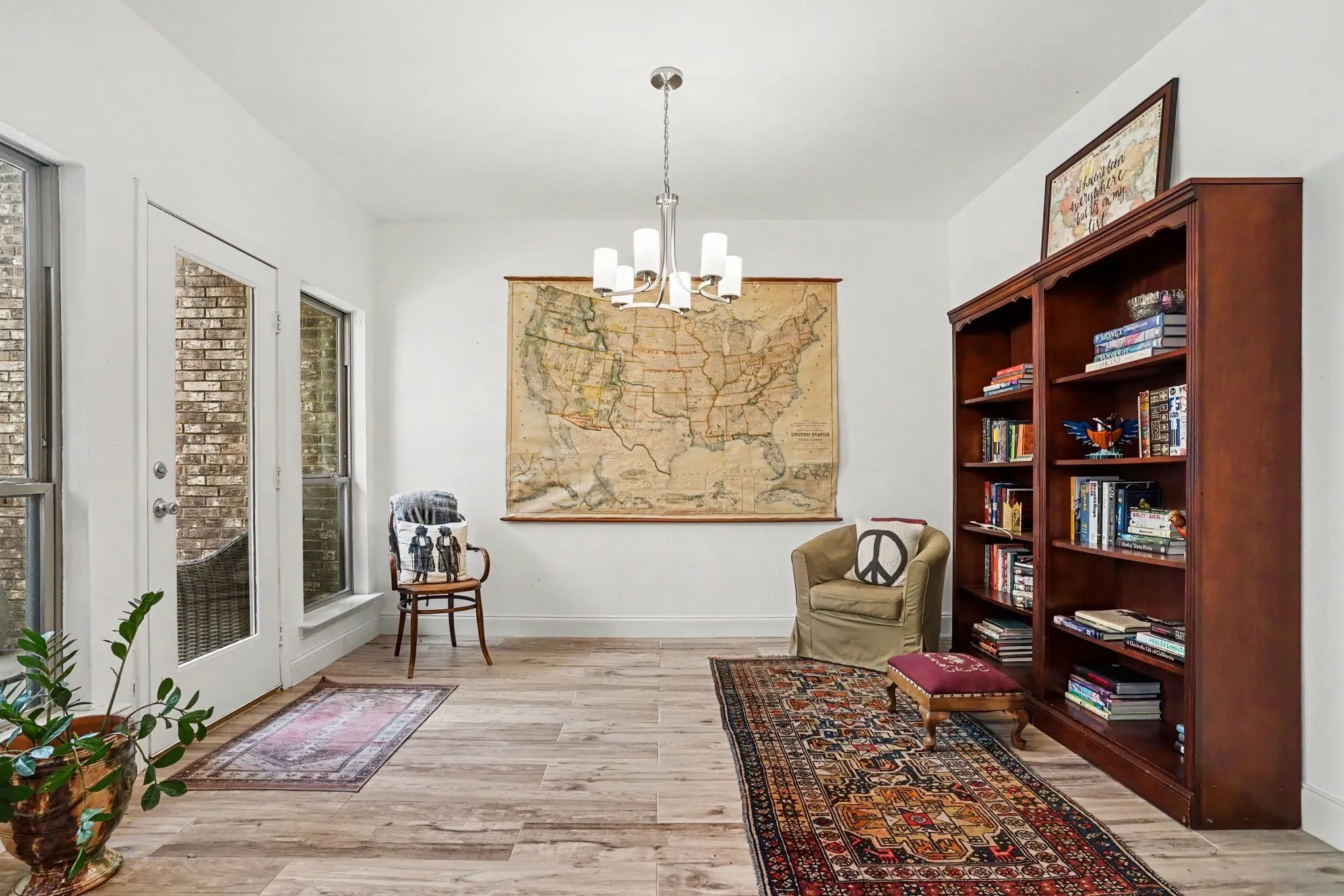 Bright interior space featuring wood-finish flooring, white walls, a multi-pane glass door, and an adjacent full-height window