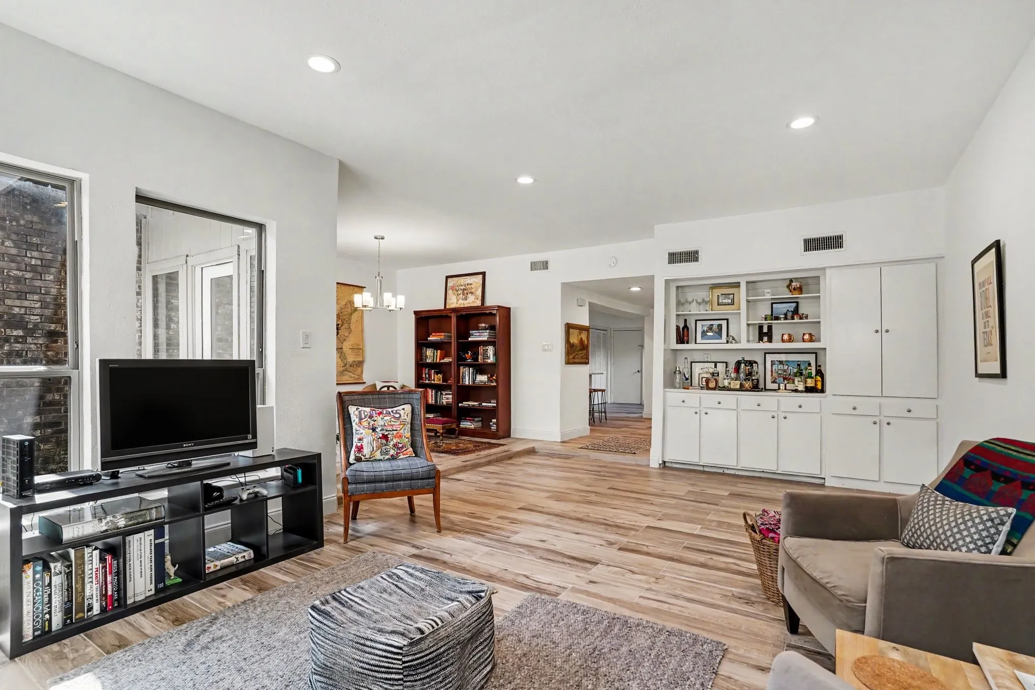 Bright living space featuring wood-finish flooring, recessed lighting, and a large window