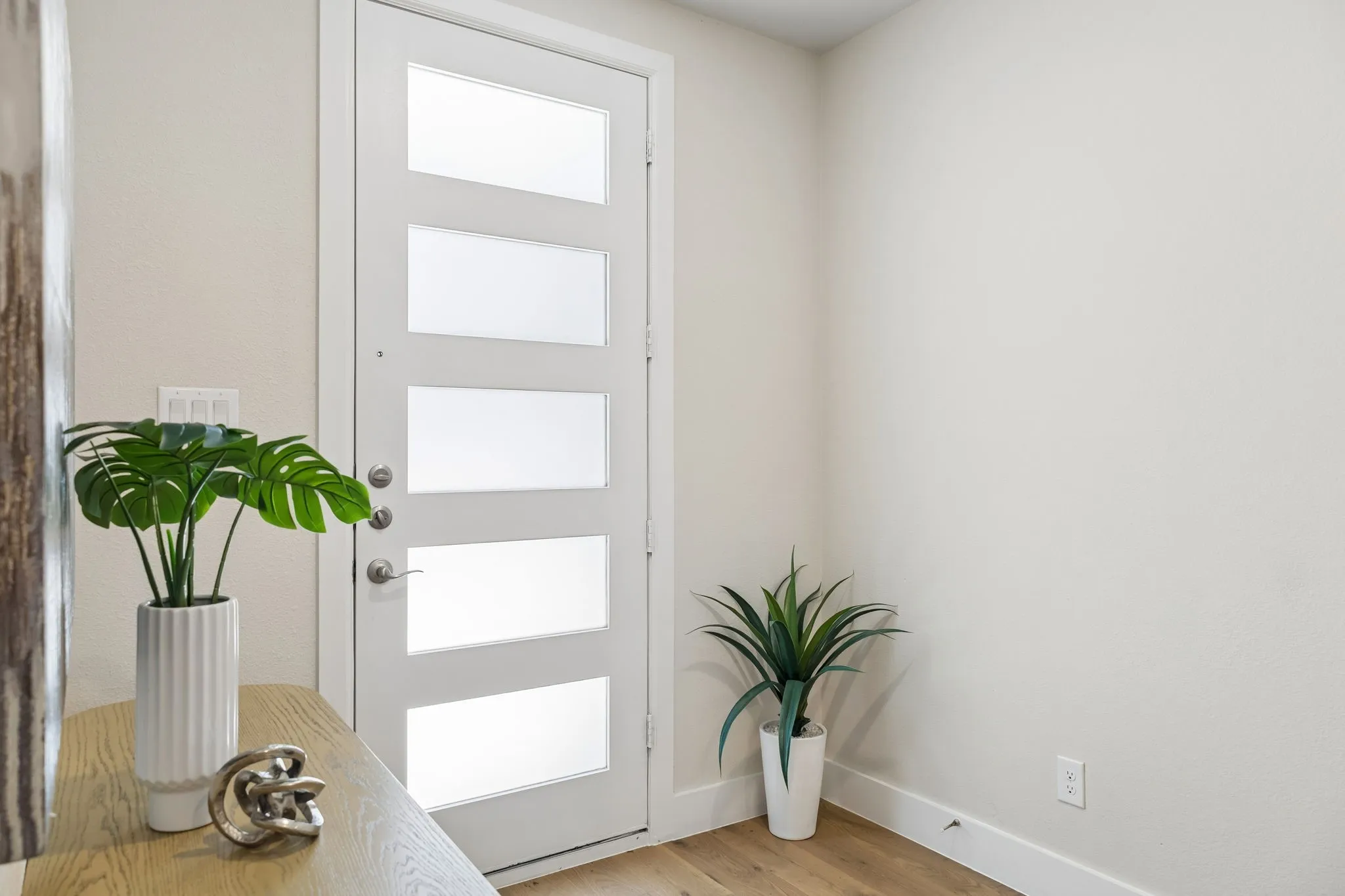 Contemporary Design from the Start
The modern front door, clean architectural details, and warm flooring create a sophisticated entry experience.