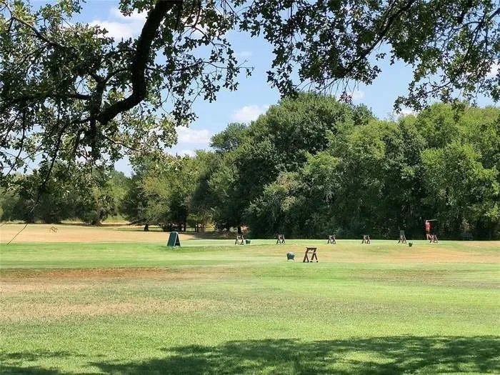 Expansive green space featuring a natural tree line backdrop