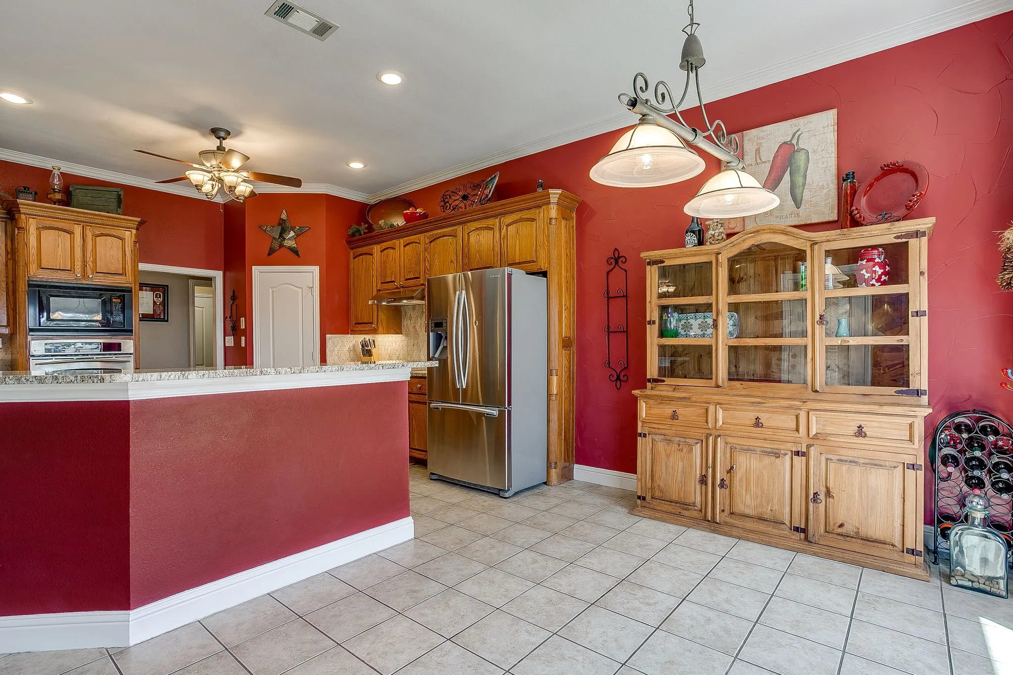 Kitchen featuring a breakfast bar, recessed lighting, ceiling fan, tile flooring, and wood cabinetry