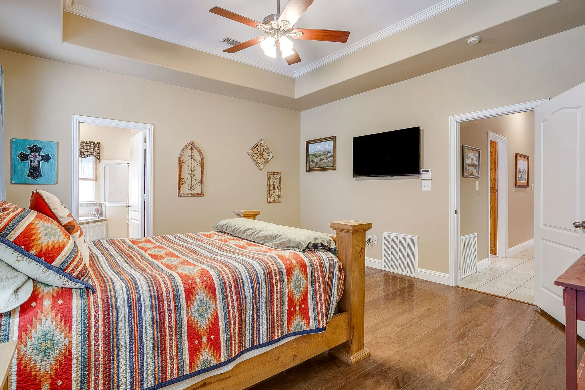 Tray ceiling with crown molding, wood-finish flooring, ceiling fan, and recessed lighting