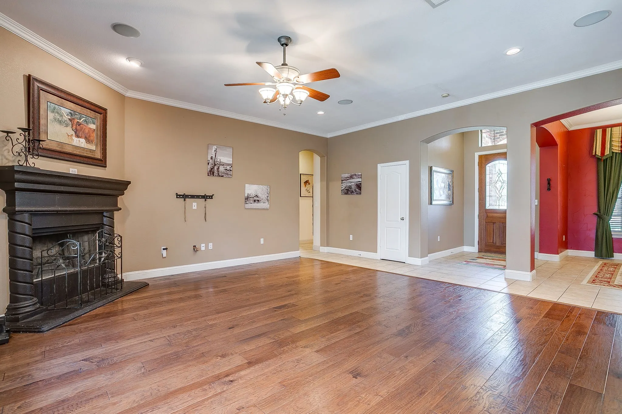 Hardwood flooring, crown molding, built-in fireplace, ceiling fan, and recessed lighting