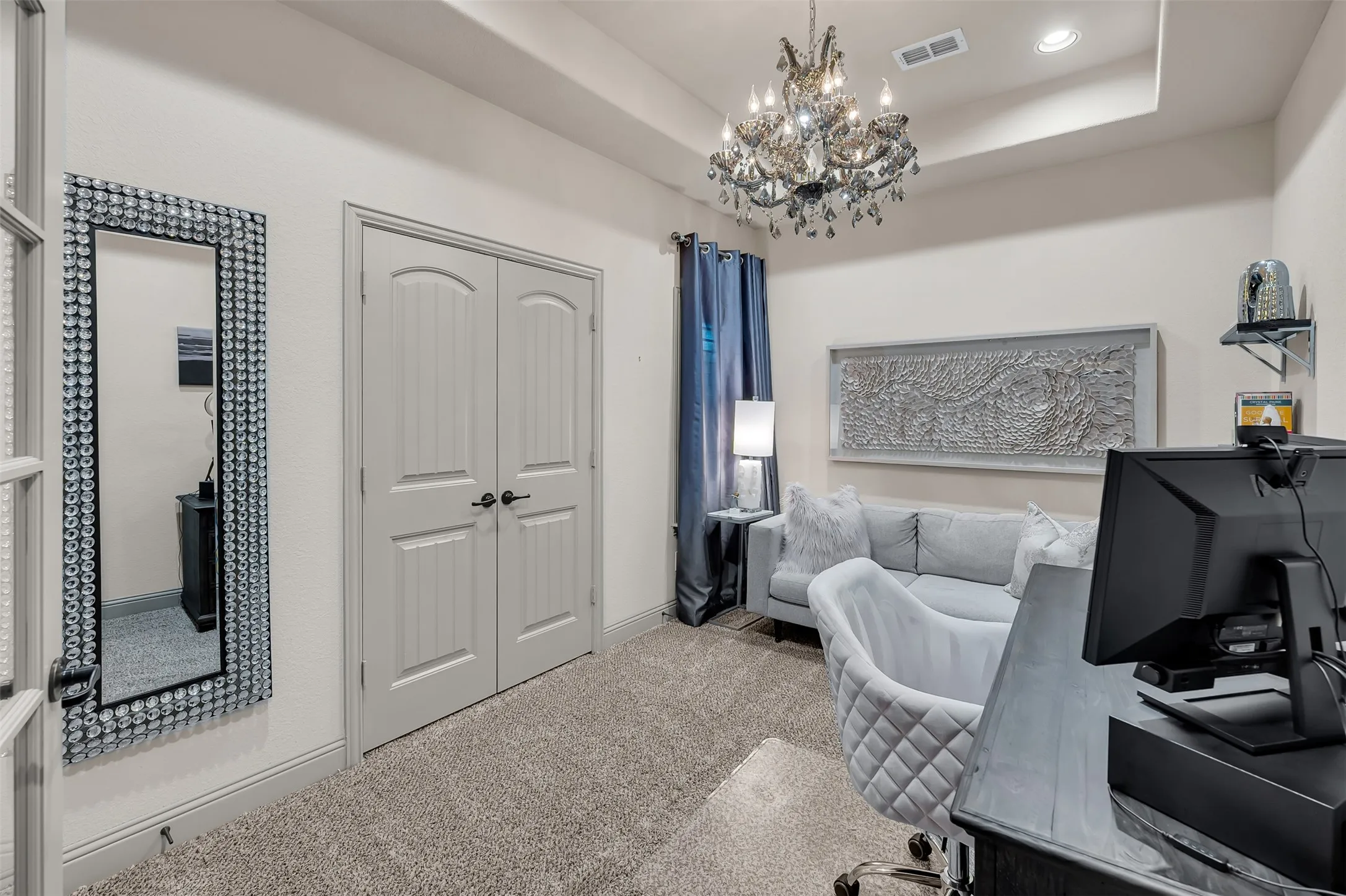 Tray ceiling with recessed lighting and a crystal chandelier