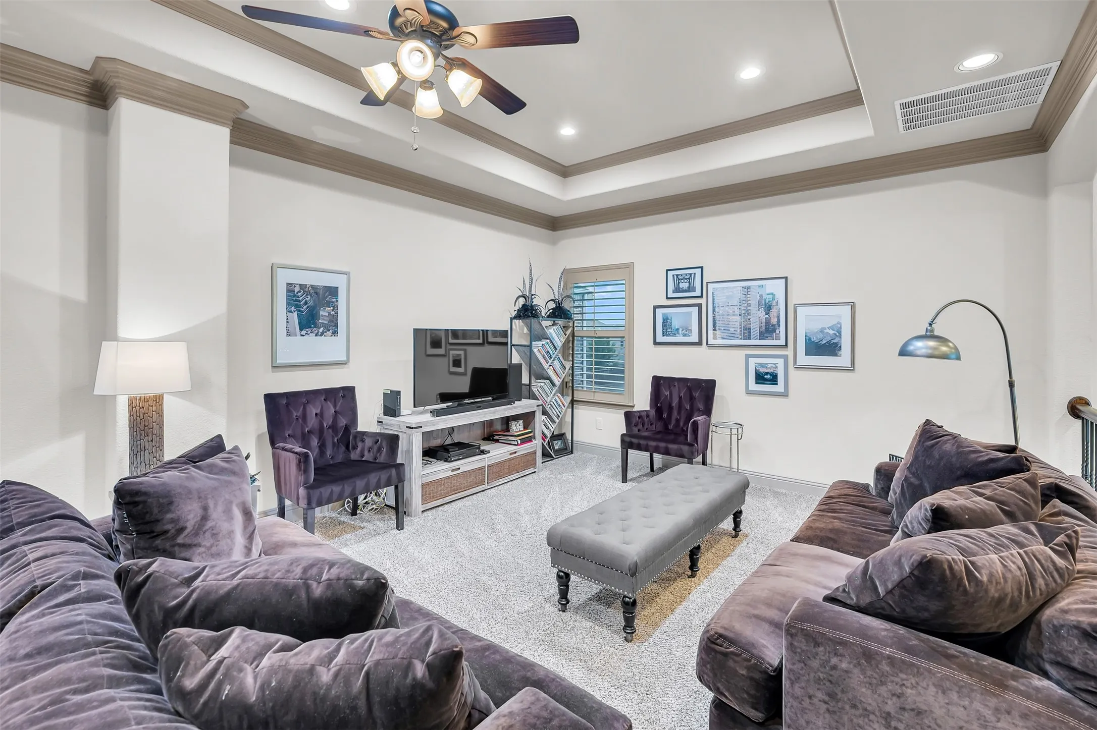 Tray ceiling with crown molding and a ceiling fan light fixture