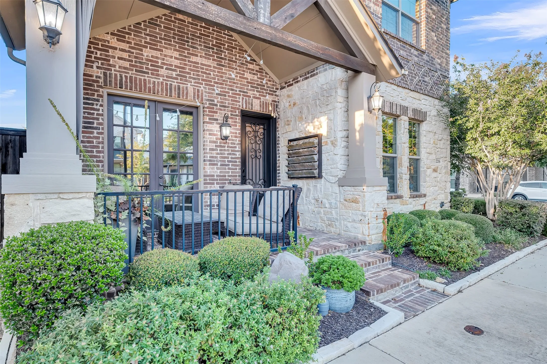 Brick and stone exterior featuring an entry porch with decorative railing