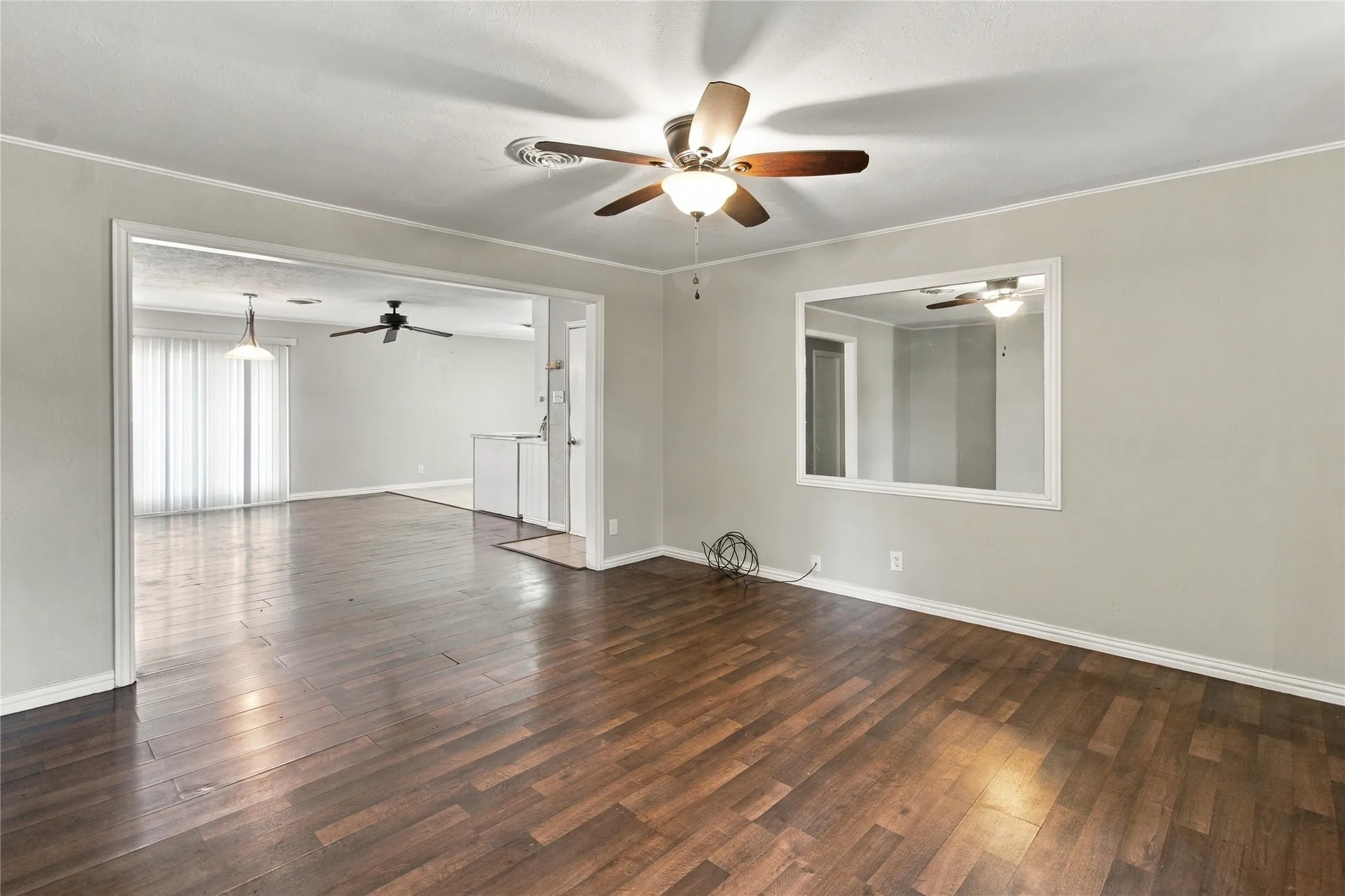 Wood-finish flooring, neutral wall tones, and overhead lighting with ceiling fan