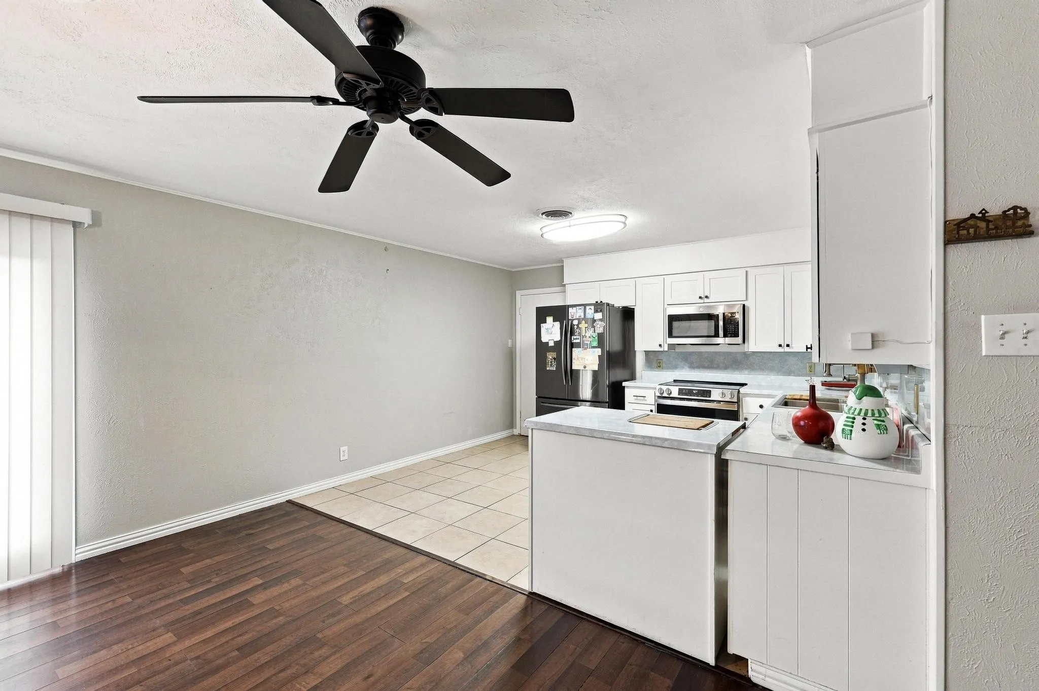 Kitchen featuring white cabinetry, stainless steel appliances, a tiled backsplash, and light-toned countertops