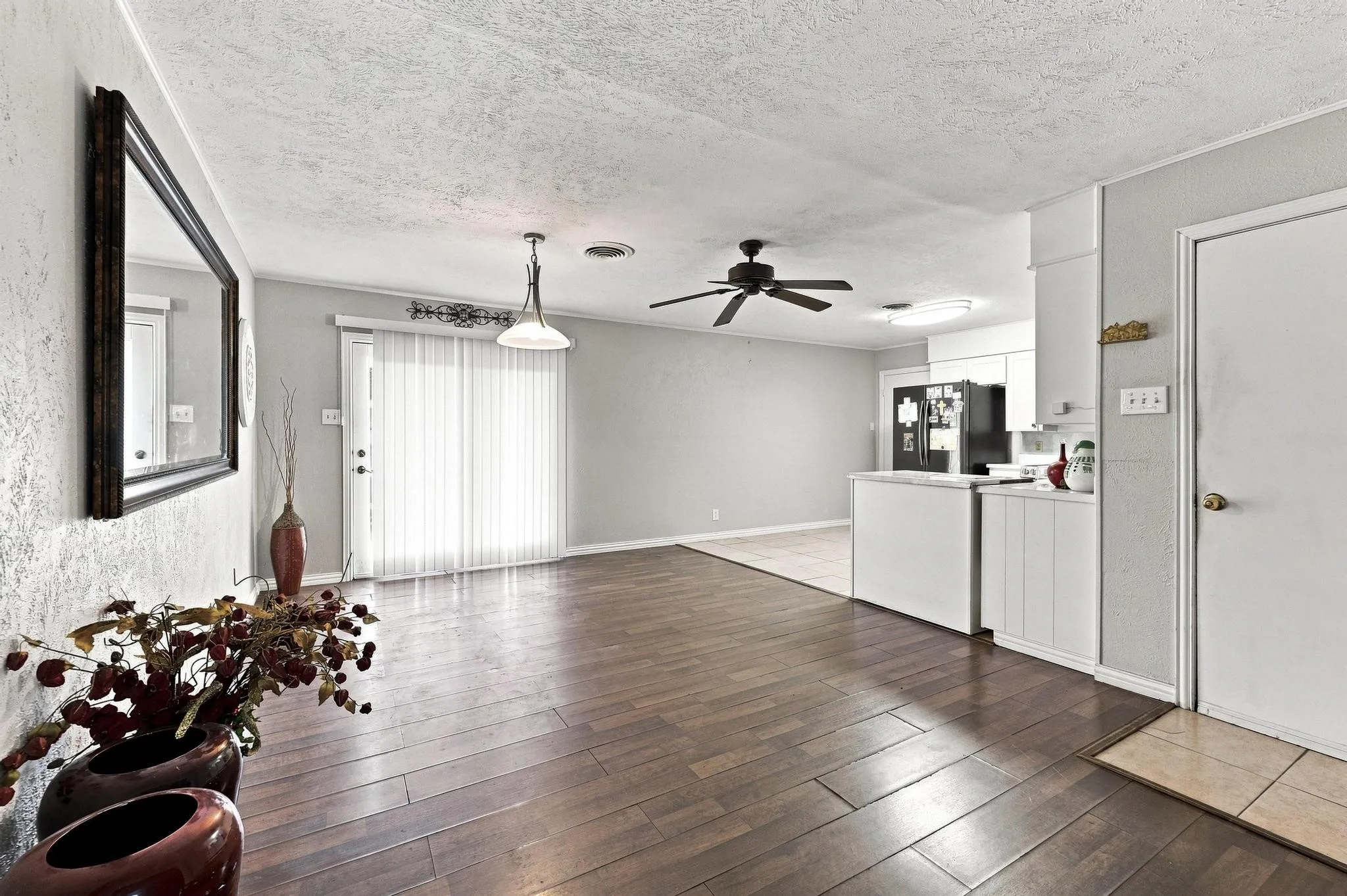 Wood-finish flooring throughout, modern ceiling fan, recessed lighting, and a white kitchen island