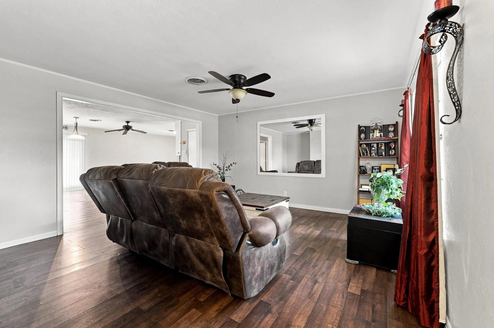 Wood-finish flooring throughout, framed openings, and a ceiling fan
