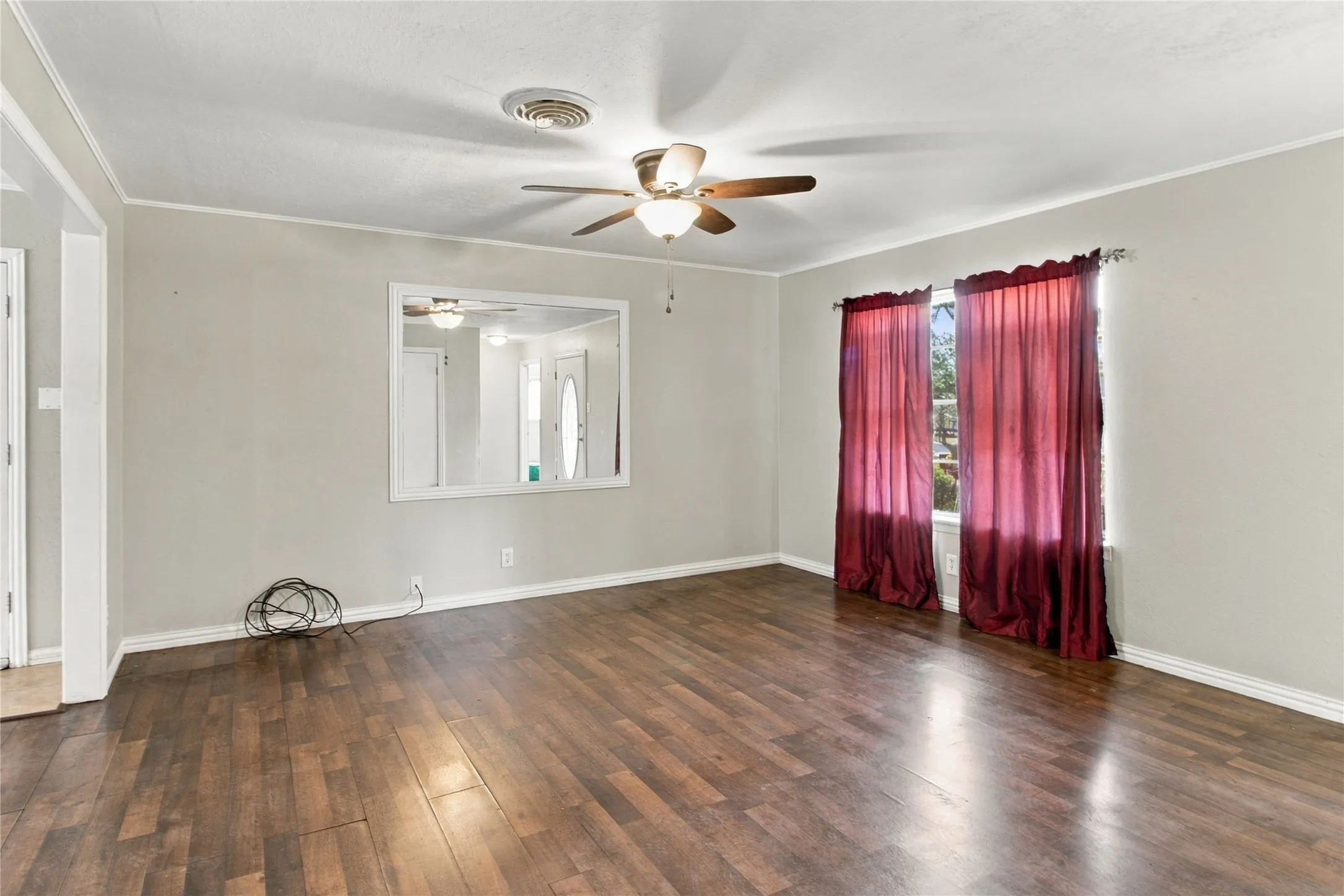 Wood-finish flooring, ceiling fan with integrated lighting, and multiple windows