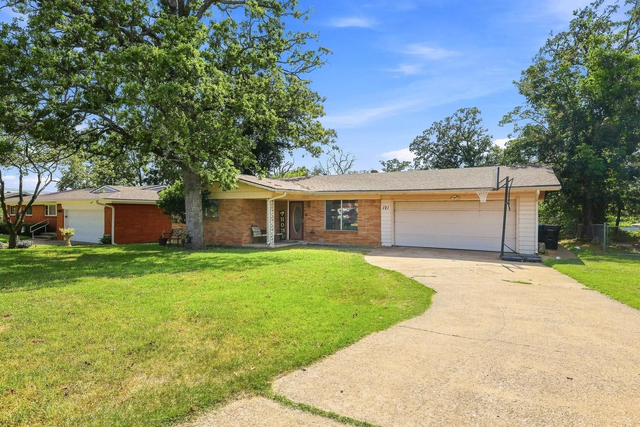 Brick exterior home featuring a concrete driveway and two attached garage doors