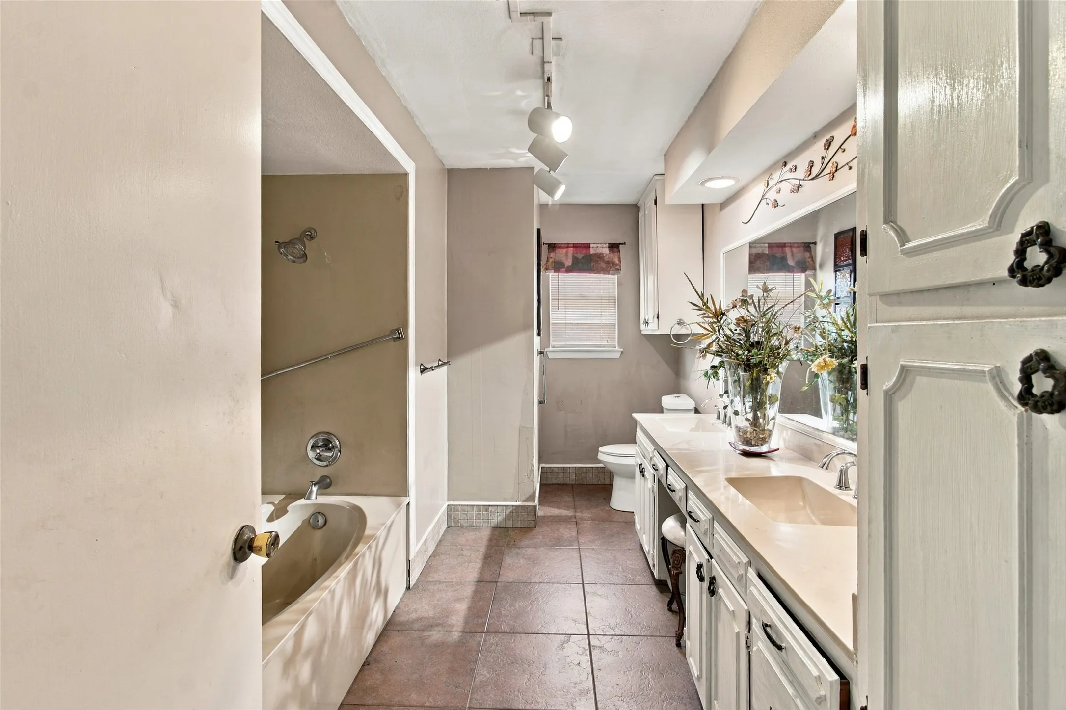 Long vanity with integrated sink, extensive counter space, and track lighting