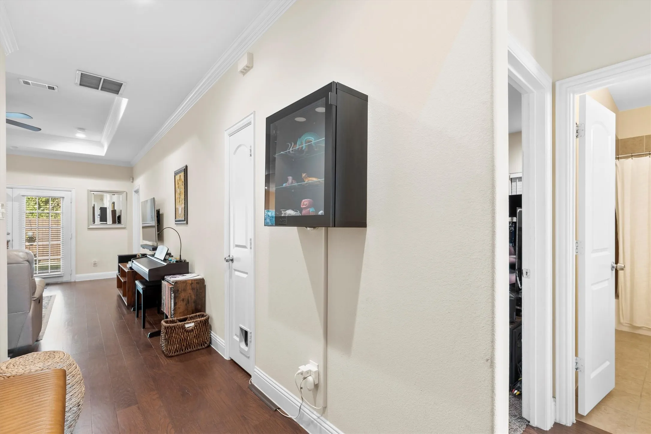 Hardwood-finish flooring extending through an open living area with a tray ceiling