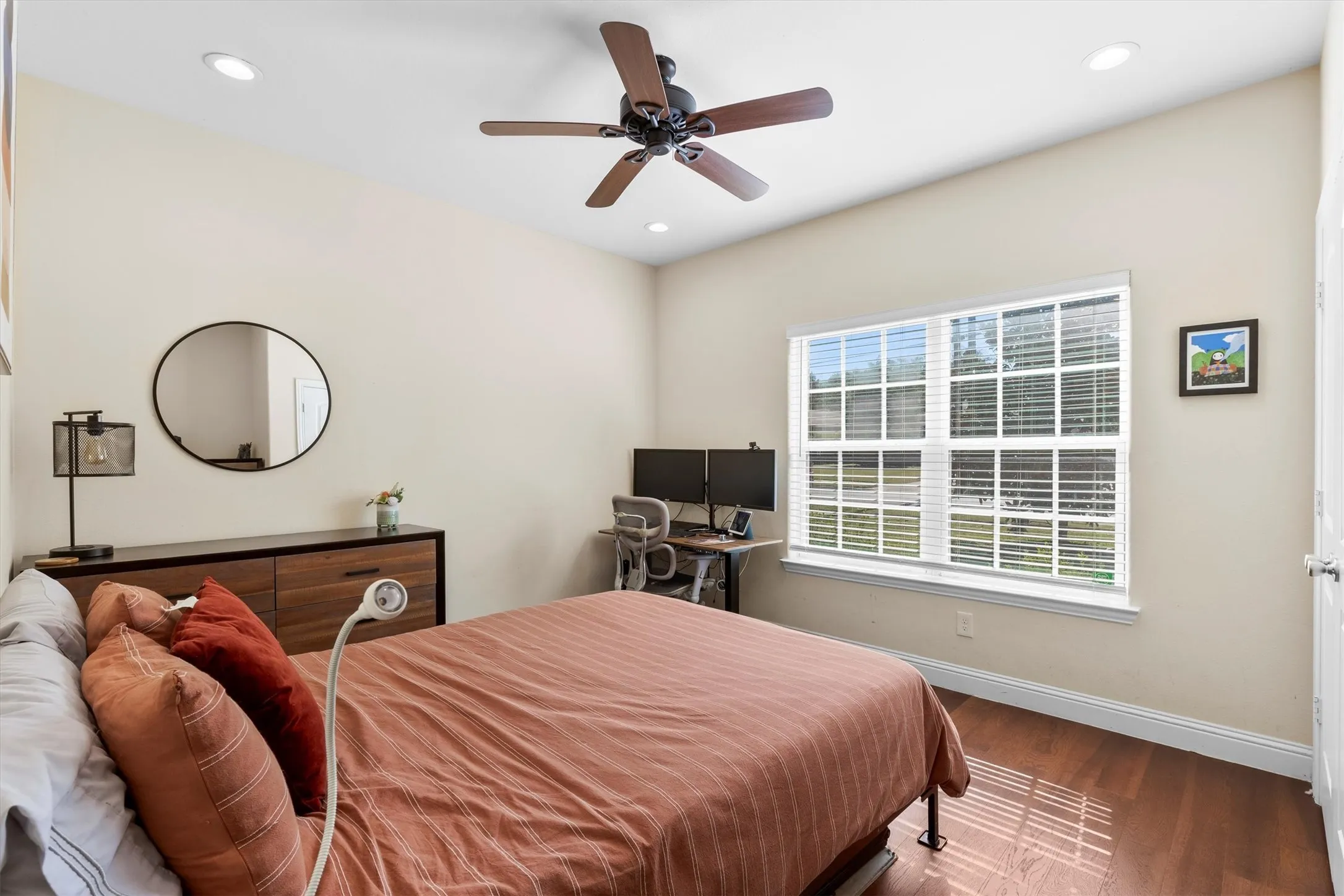 Spacious room featuring vaulted ceilings, recessed lighting, a ceiling fan, a large window with horizontal blinds, and wood-finish flooring