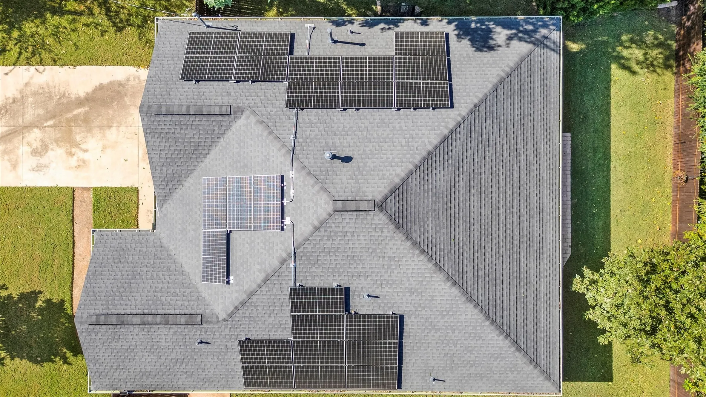 Gable and hip roofline featuring multiple solar panel arrays