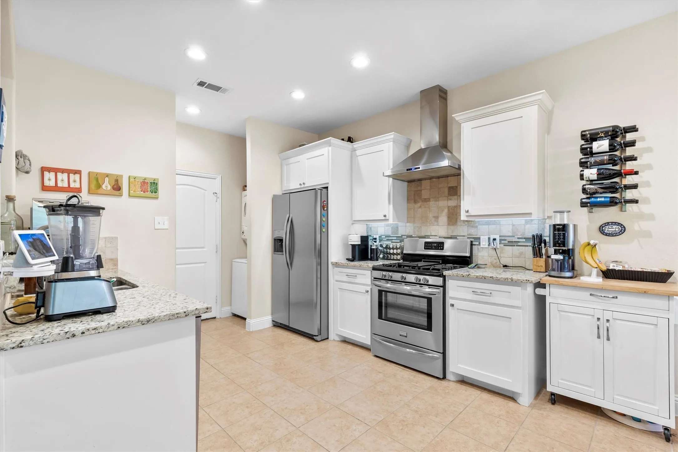 Modern kitchen featuring stainless steel appliances, including a gas range and refrigerator