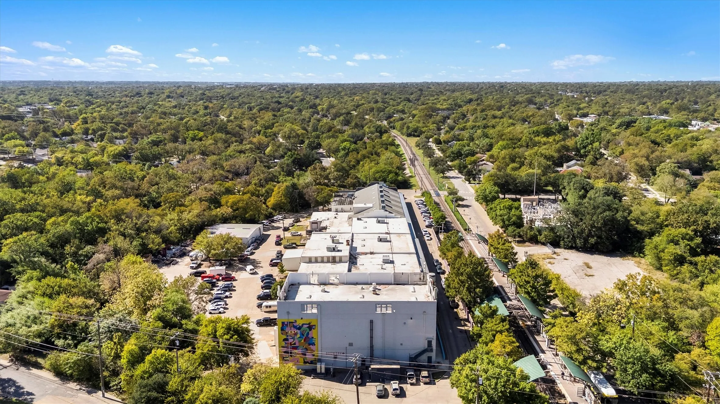 Extensive commercial property featuring multiple structures, ample parking areas, and convenient rail access