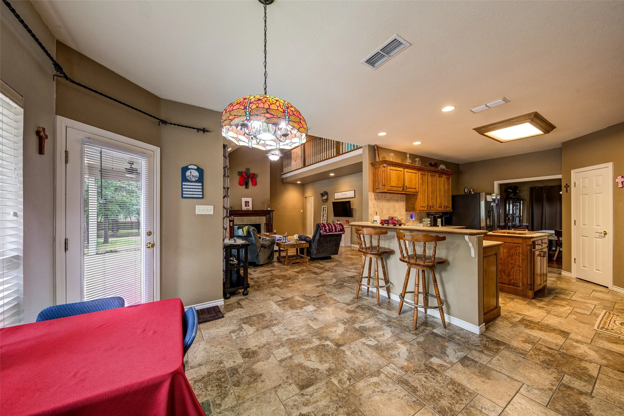 Spacious kitchen featuring a breakfast bar, wood cabinetry, and recessed lighting