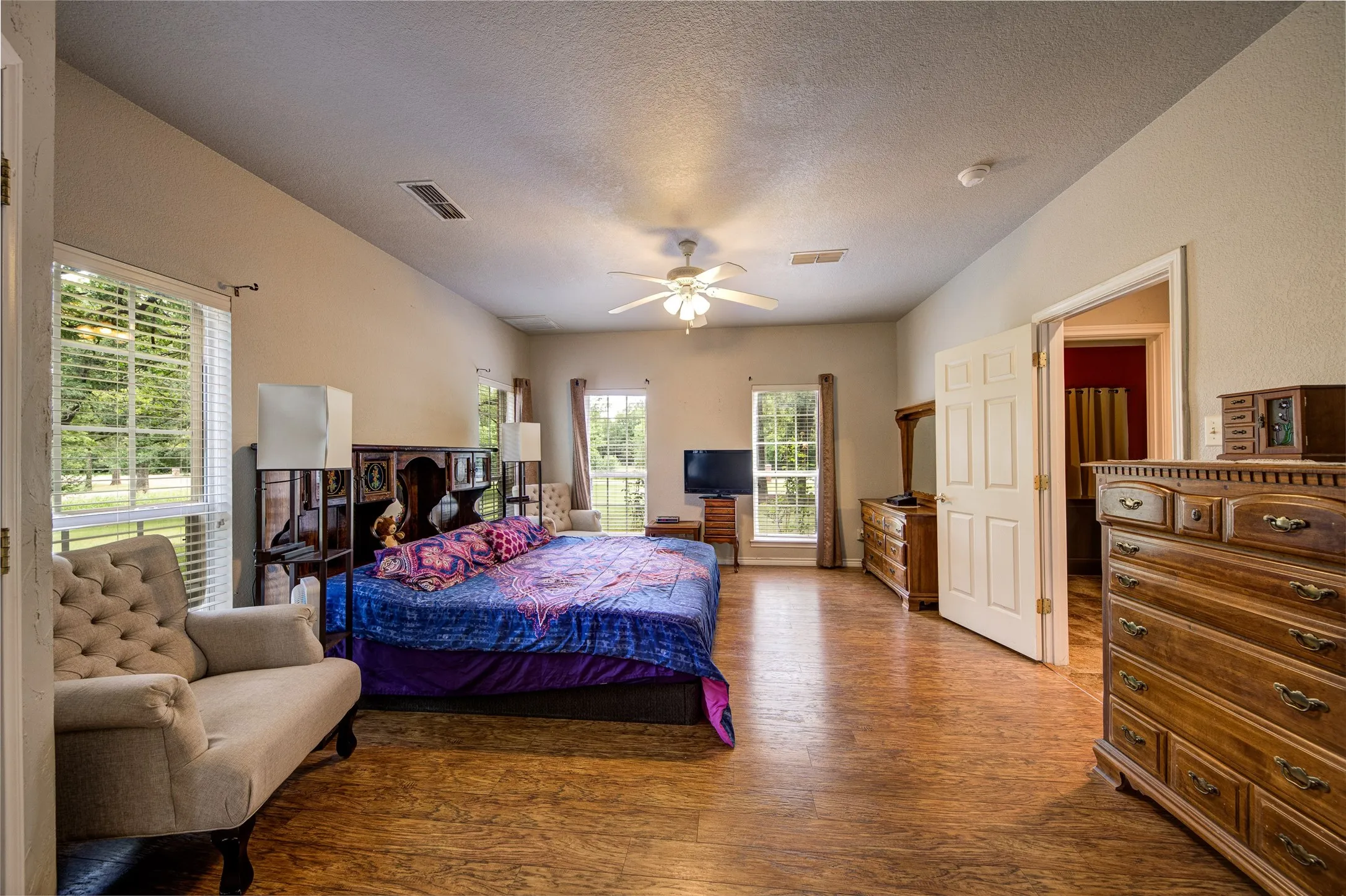 Spacious room featuring wood-finish flooring and a vaulted ceiling