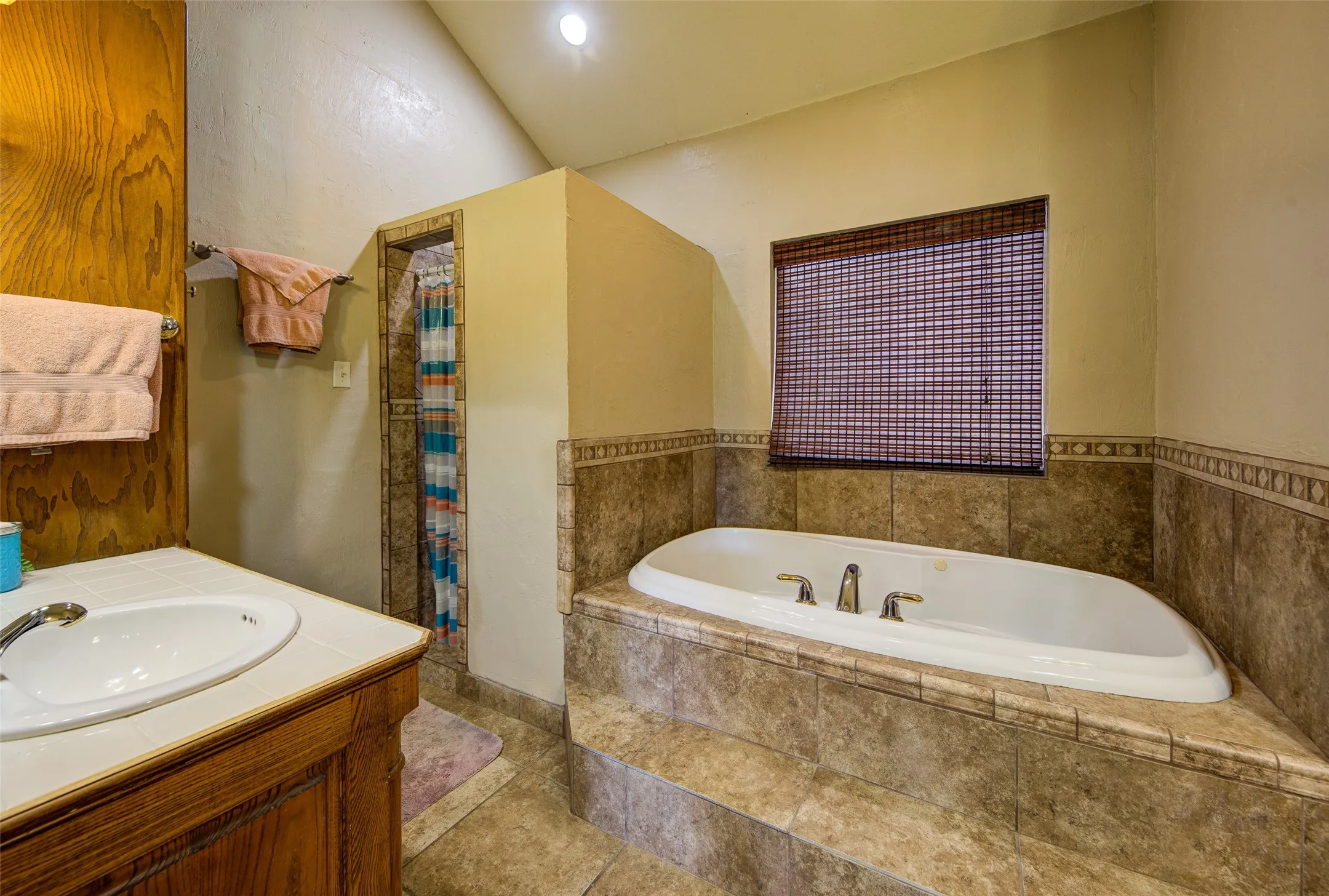 Soaking tub with bronze-finish fixtures set in a tiled surround