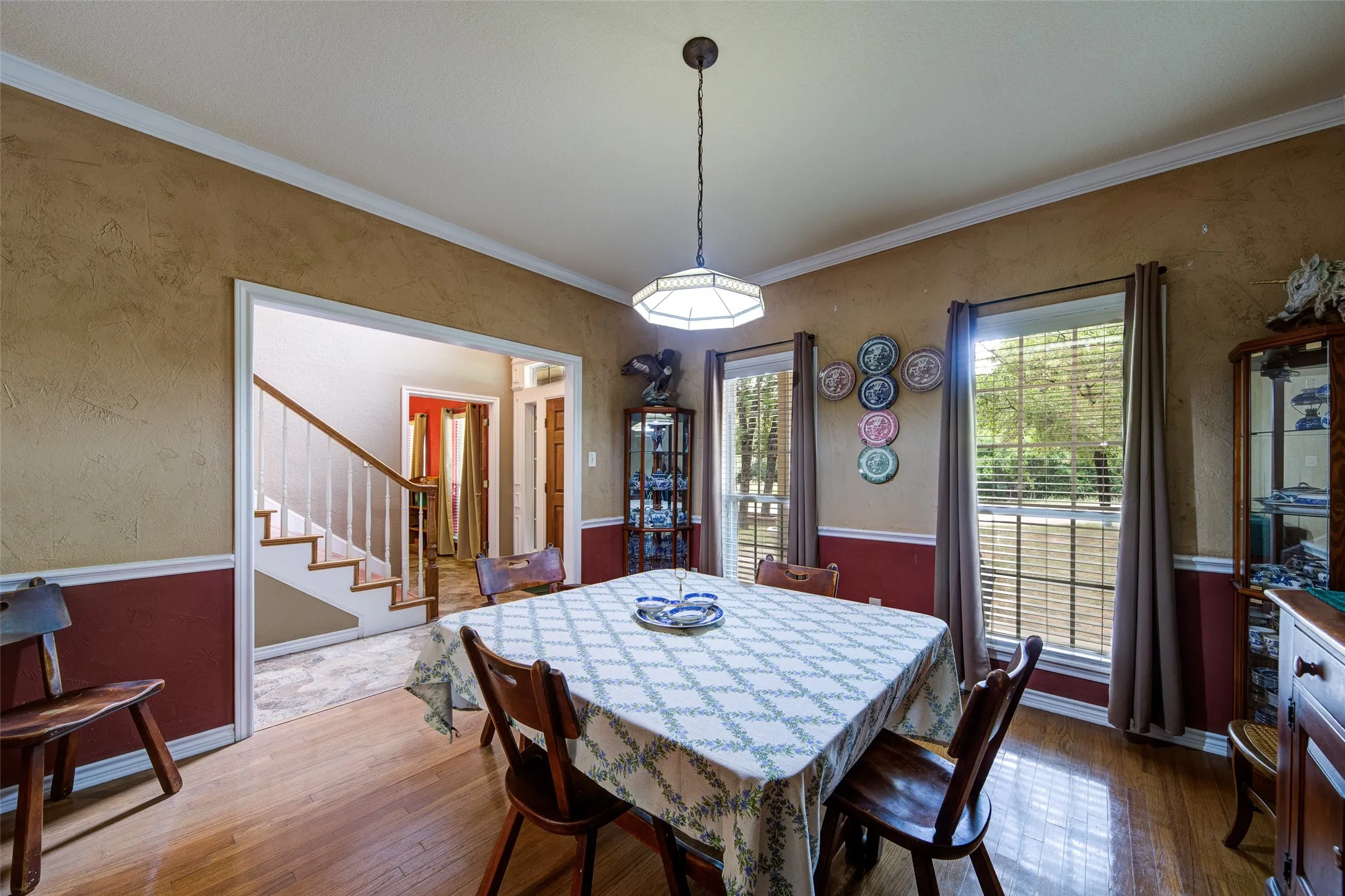 Dining area featuring wood-finish flooring, crown molding, and a chandelier-style light fixture