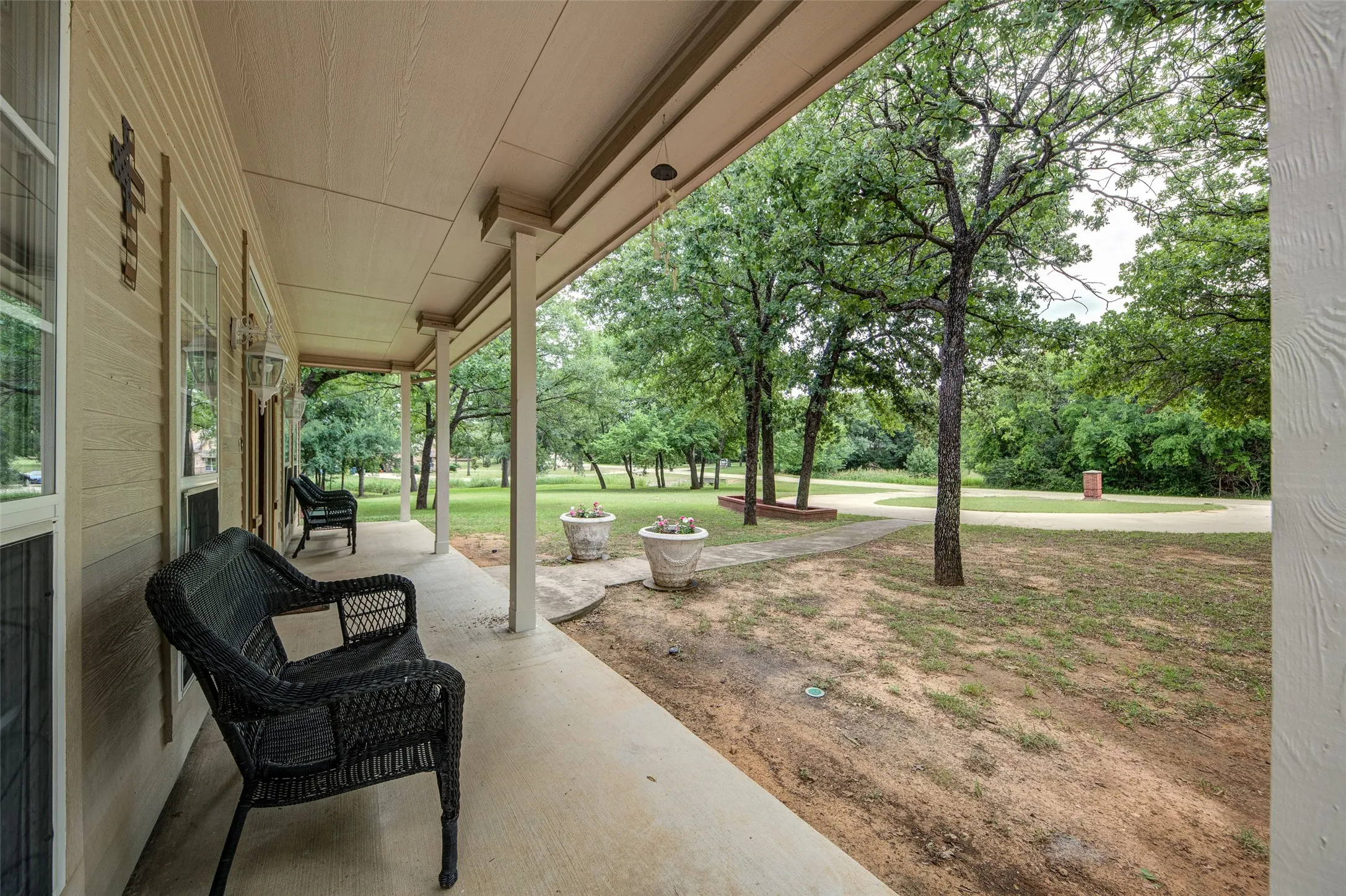 Covered concrete porch with light-colored siding